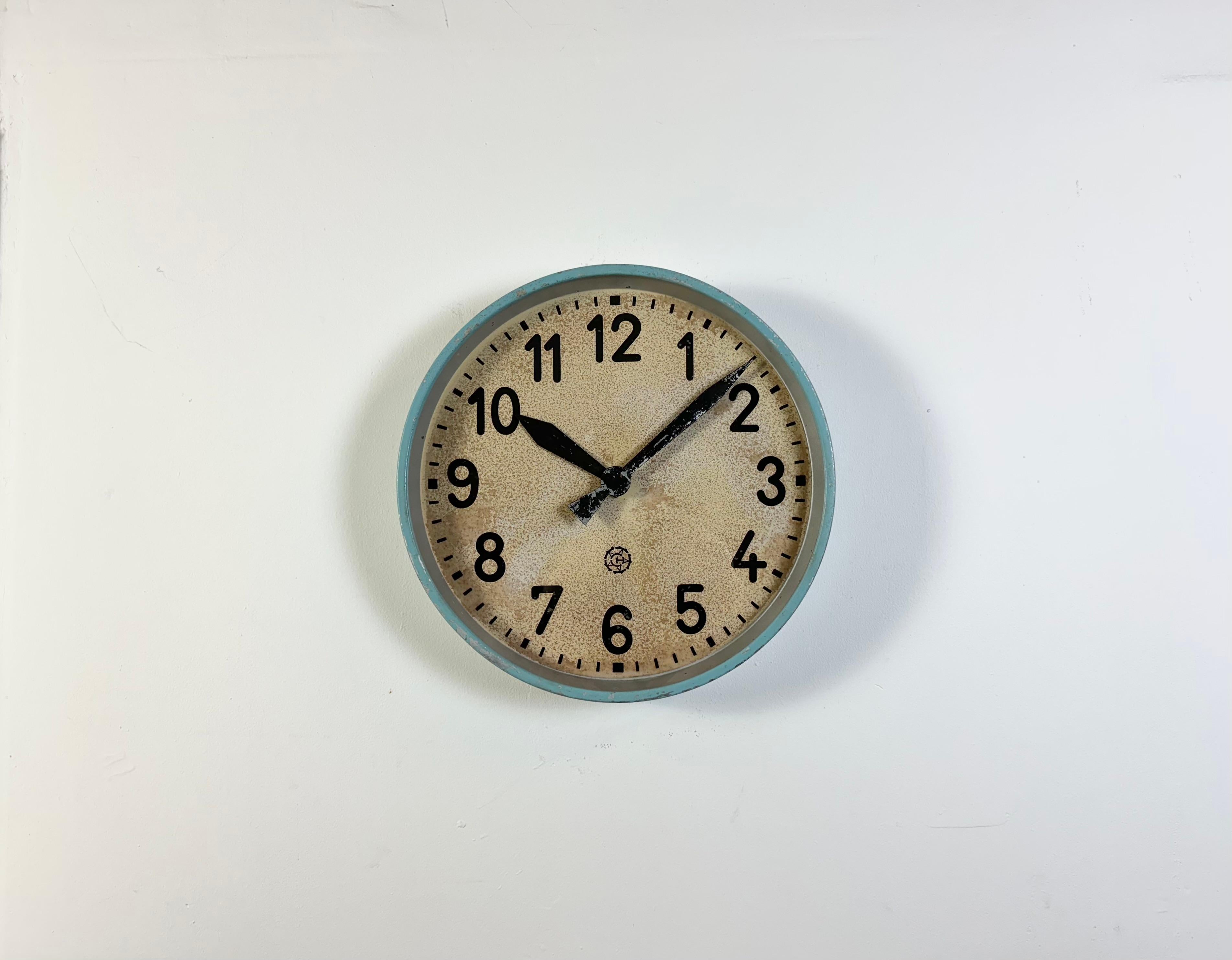 Cette horloge murale a été produite par Chronotechna dans l'ancienne Tchécoslovaquie au cours des années 1950. Elle présente un cadre en métal bleu, un cadran en fer, des aiguilles en aluminium et un couvercle en verre transparent. La pièce a été