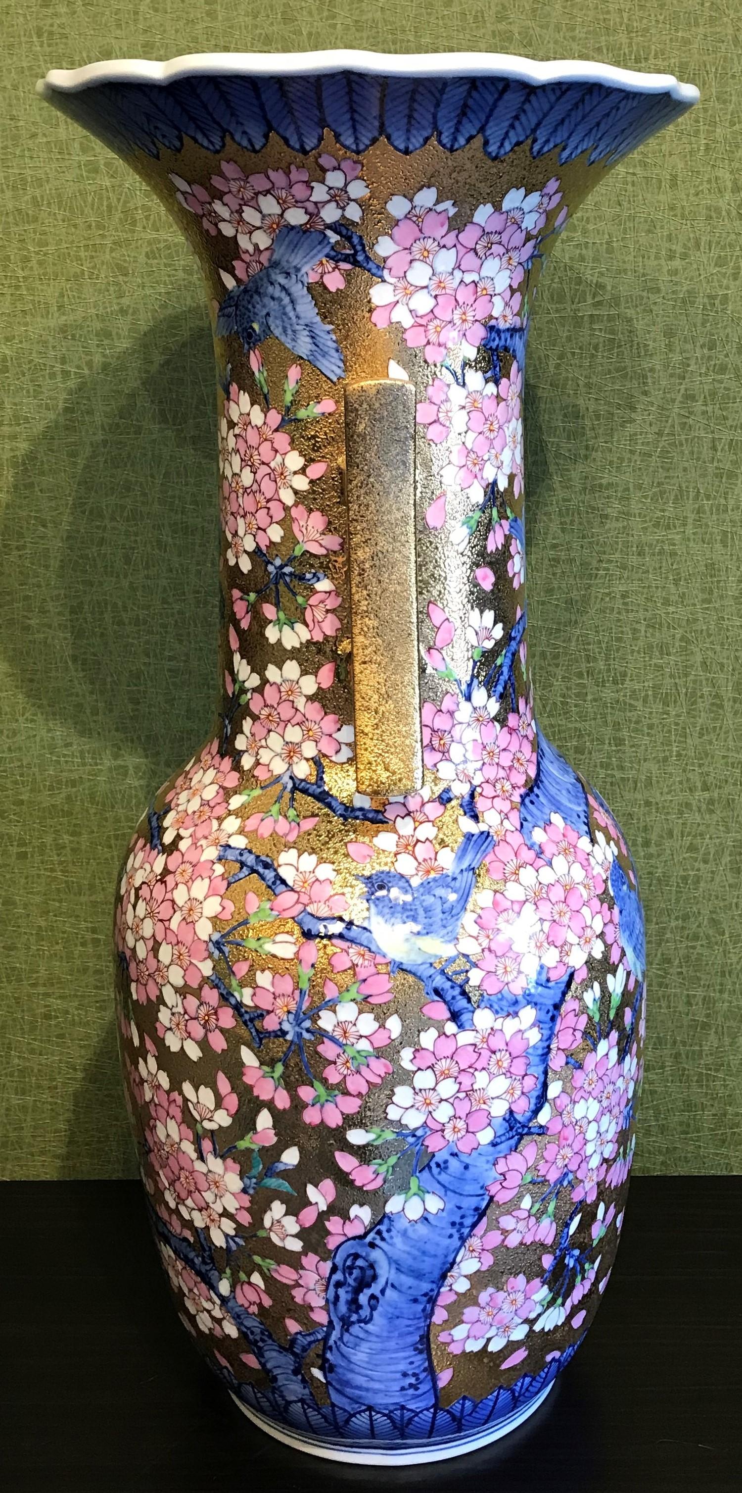 Extraordinary very large contemporary Japanese gilded porcelain vase with decorative handles, intricately hand painted in pink and blue on an opulently textured gold background. This piece is a masterpiece by highly respected award-winning master