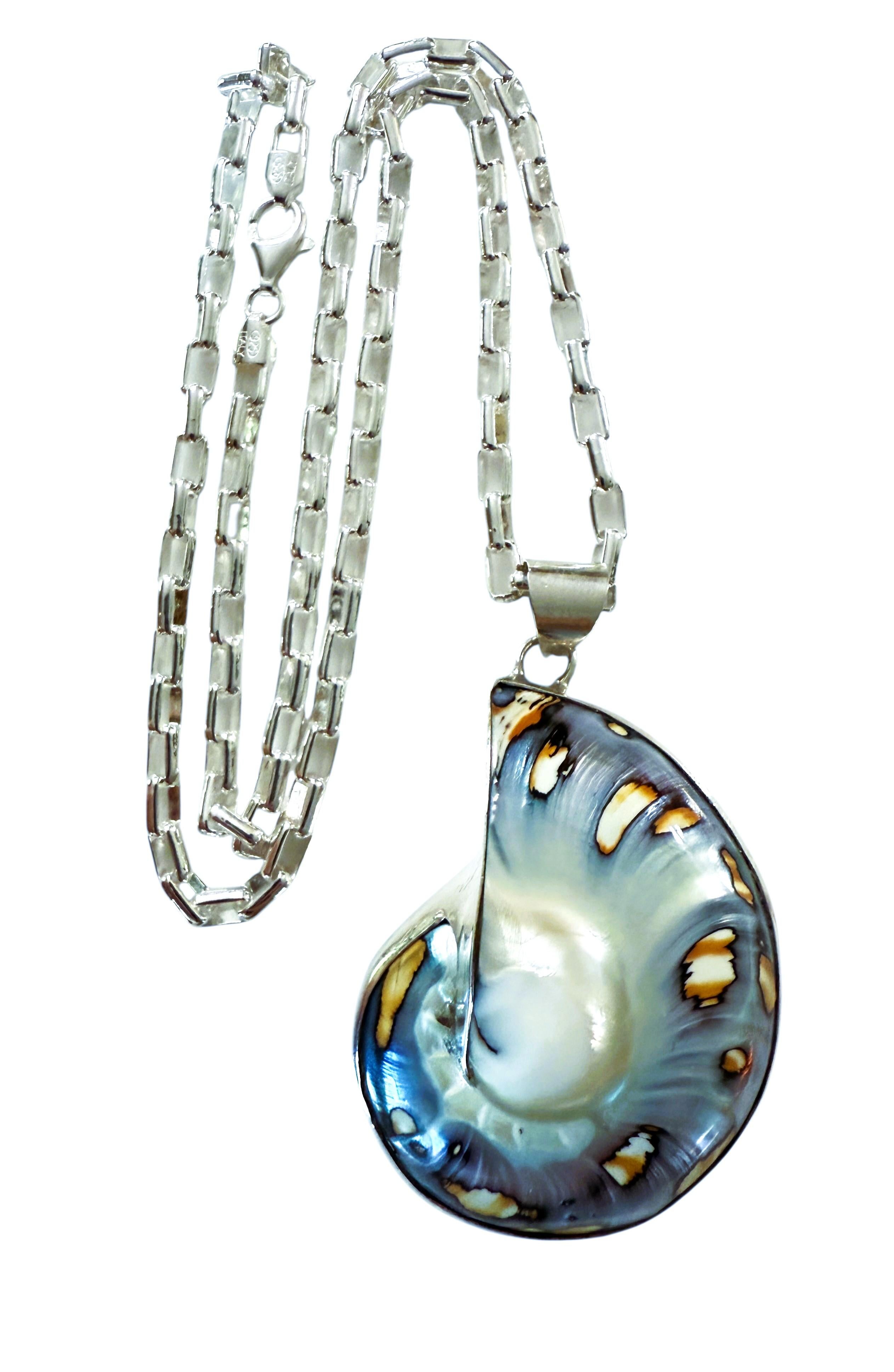 Este collar es precioso y tiene un diseño fabuloso.  Es realmente un collar de declaración maravilloso.  Se trata de una gran concha Nautilus engarzada en plata de ley 925.  El colgante mide 2,5 pulgadas de largo, incluida la presilla, y 1,5