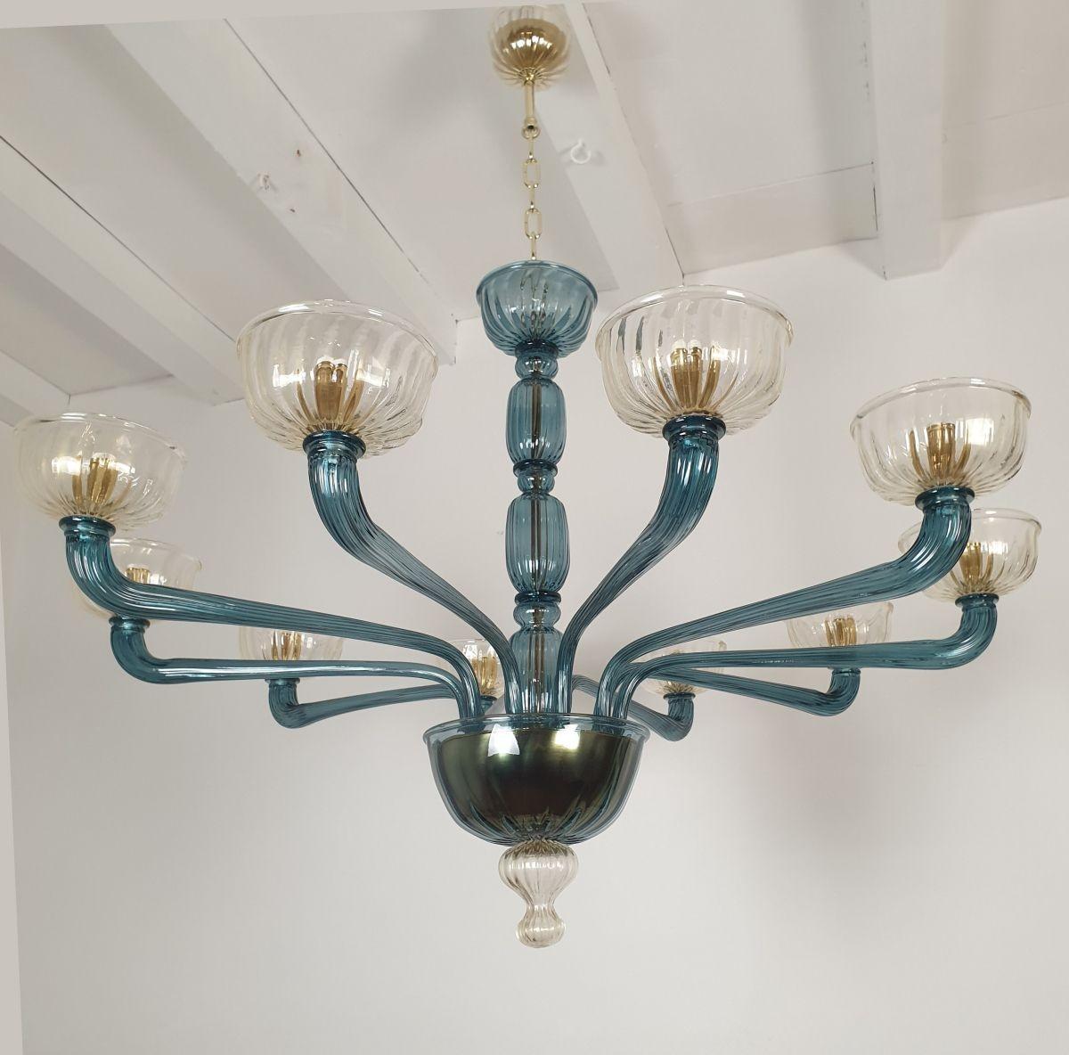 Large Mid-Century Modern petrol blue and clear-gold Murano glass chandelier Venini style, Italy 1970s
The neoclassical style Murano glass chandelier has ten light and arms.
The chandelier is made of a translucent petrol blue Murano glass and clear