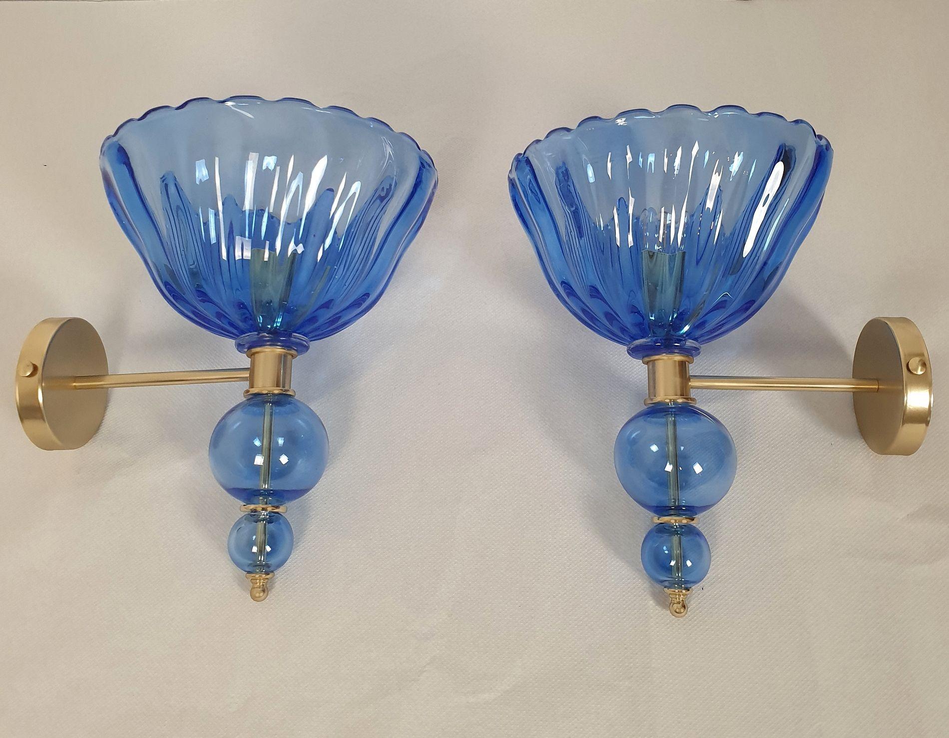 Pair of large Hand-blown Murano glass sconces, attributed to Barovier and Toso, Italy 1980s.
The Murano glass is thick, translucent and in a medium Blue color.
The mounts are made in brass and gold plated metal.
The diameter of the round back