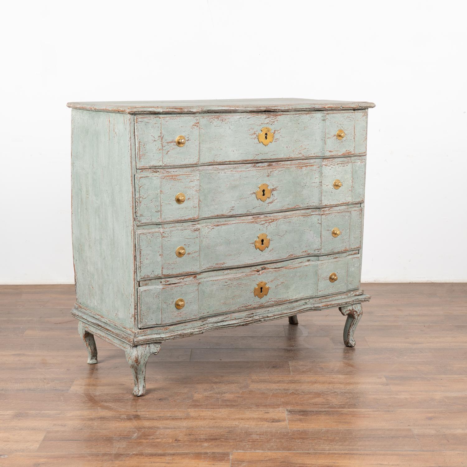 Large antique oak chest of four drawers with handsome brass hardware pulls all resting on cabriolet feet.
It has been given an exceptional new professional pale blue/seafoam layered painted finish and has been lightly distressed, bringing out the
