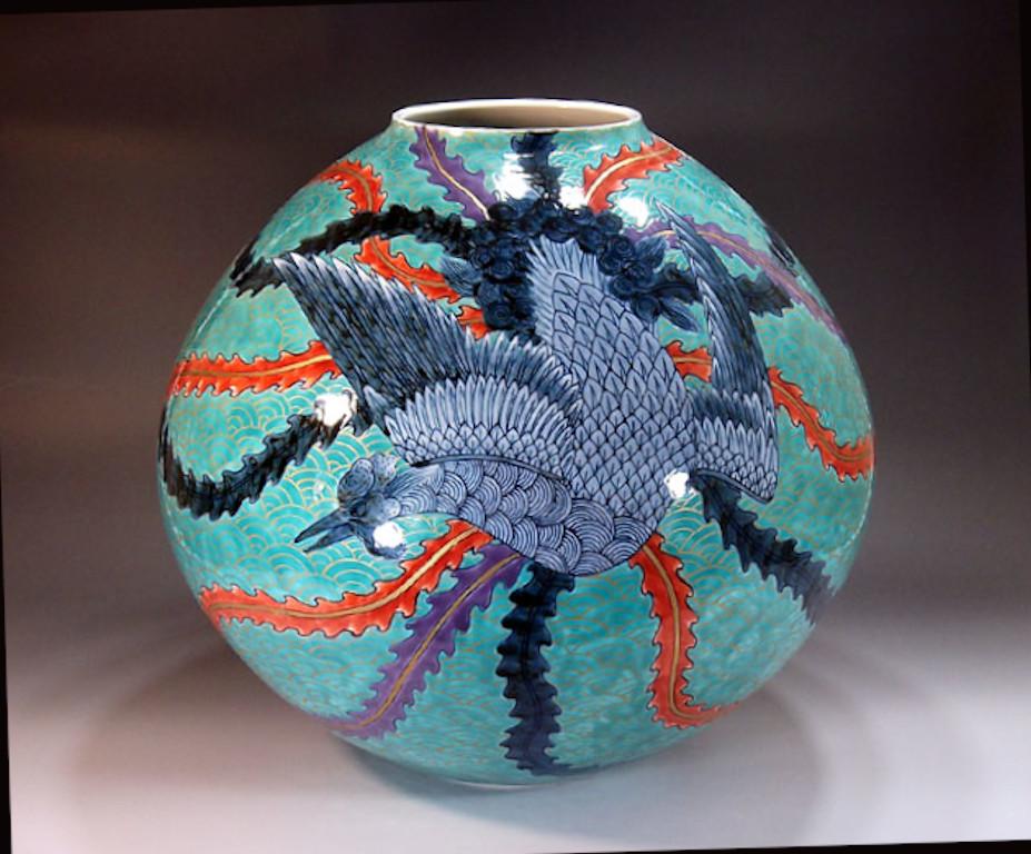 Exquis vase décoratif japonais contemporain en porcelaine, peint à la main de façon complexe en bleu, rouge et violet sur un magnifique fond turquoise, de forme ronde, chef-d'œuvre signé par un maître porcelainier primé et largement acclamé dans le