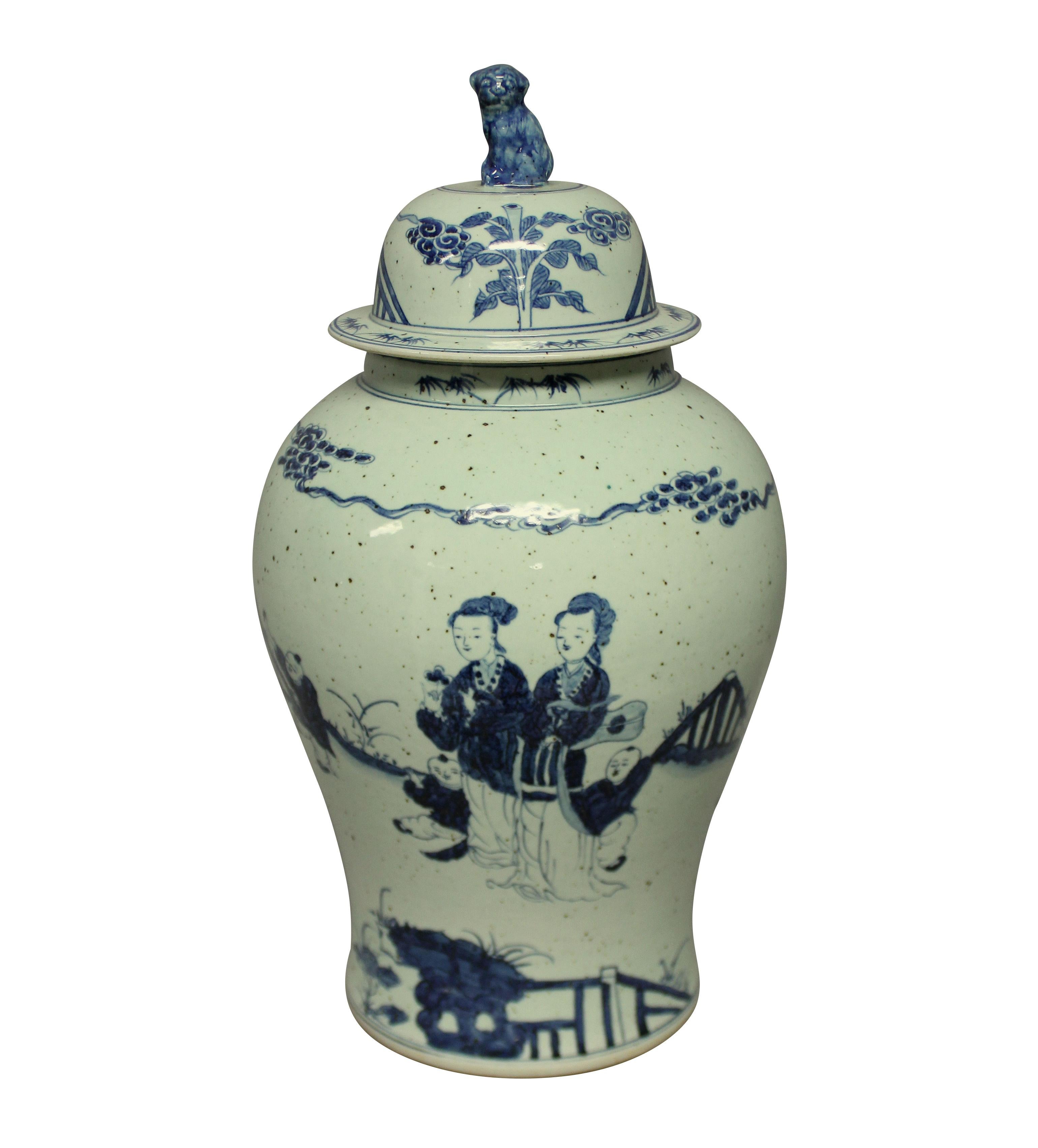 A large Chinese blue and white covered vase, with scenes on all sides. The background colour is pale duck egg.