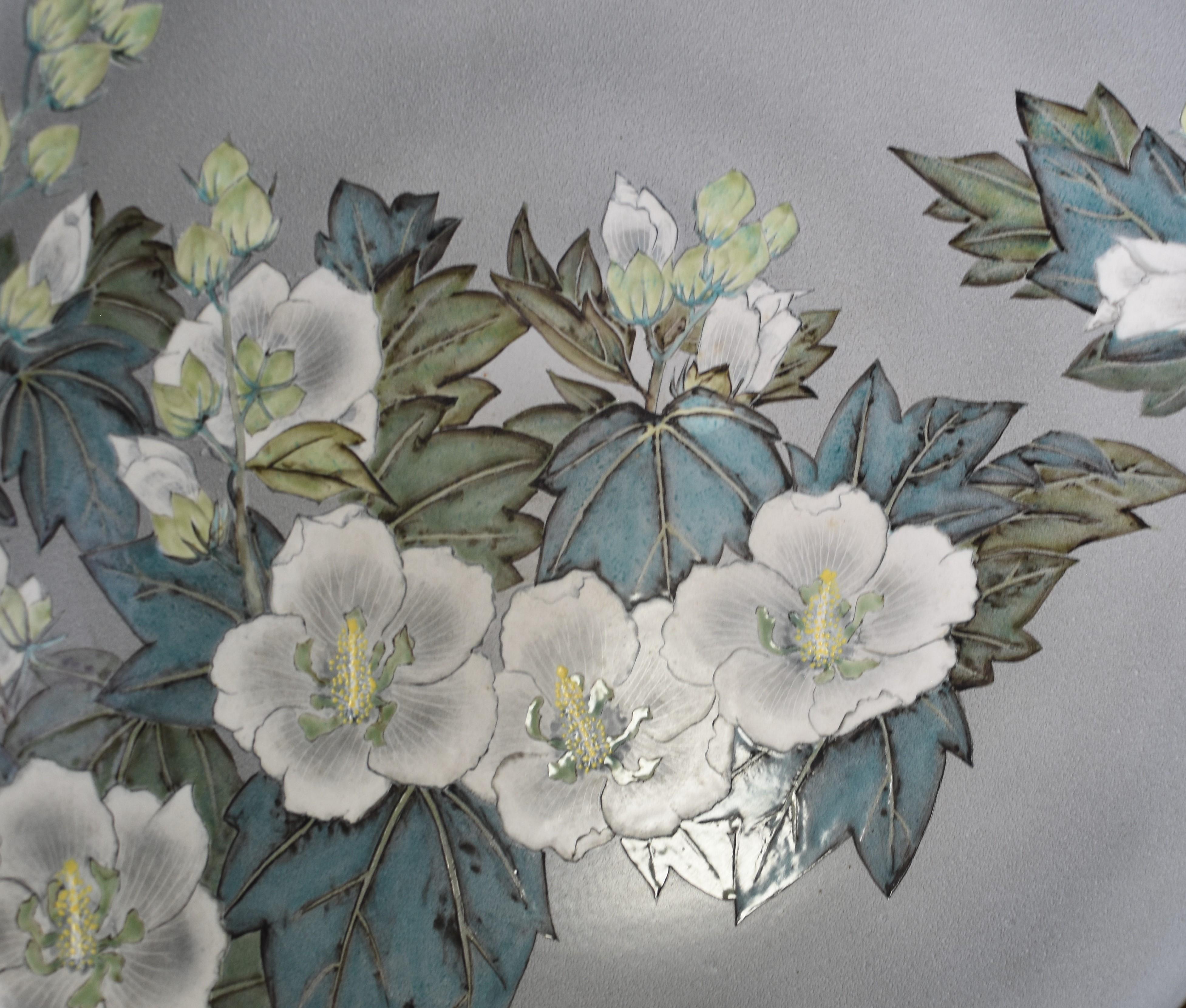 Exquisite very large contemporary ceramic deep charger/centerpiece, hand painted in green, blue and white on an attractive silver/gray background to feature a stunning bold flower and foliage motif that creates a striking contrast against the