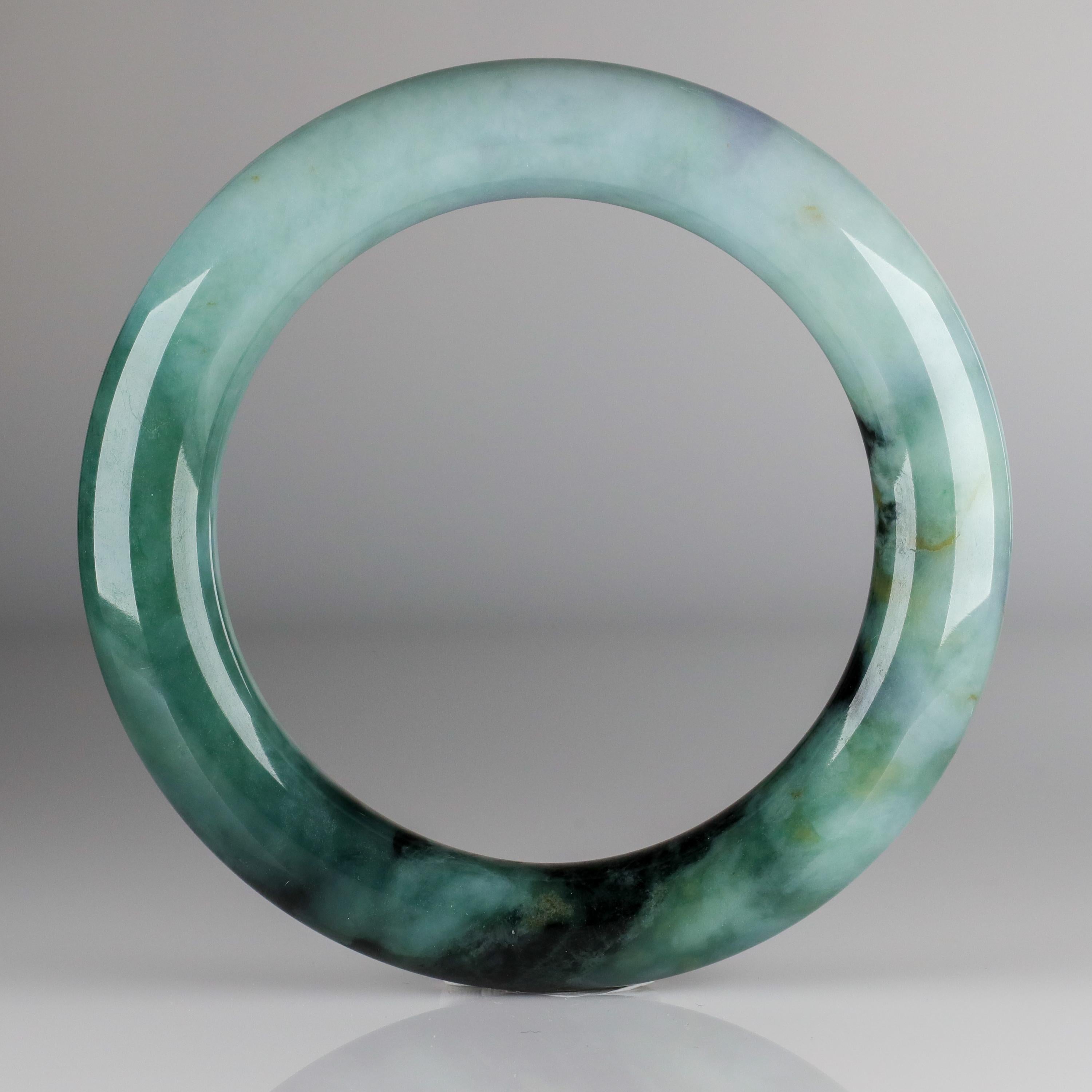 A spectacular certified natural and untreated jadeite jade bangle hand-carved in a larger size, suitable for many men. The average jade bangle hs an inner diameter of between 50-54mm, which fits many women. This bangle has an exterior diameter of
