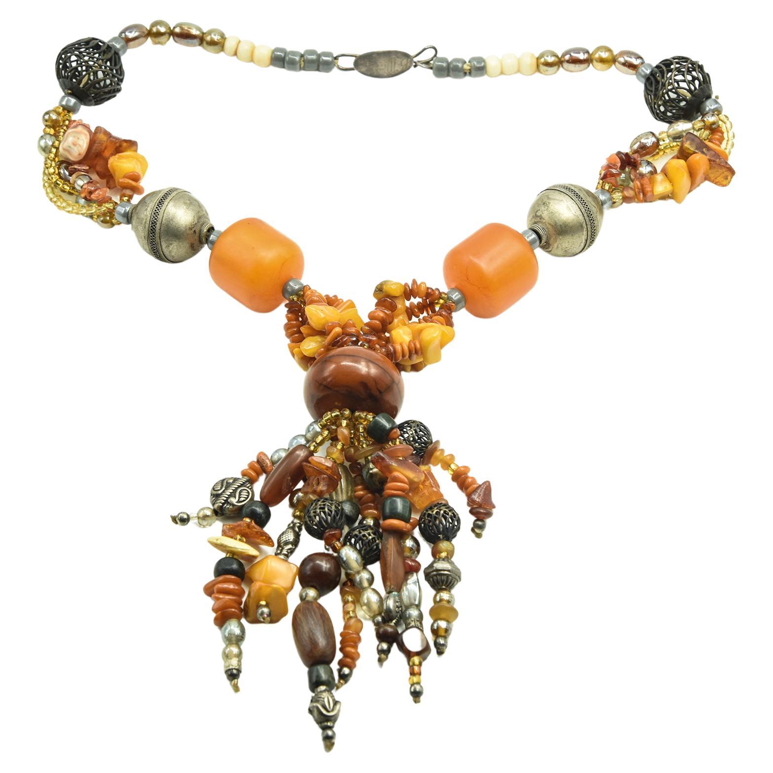Unique handmade tassel necklace featuring amber, wood, bone, glass and metal beads.    

Marked on the clasp B. Marie                                                                                                                                    