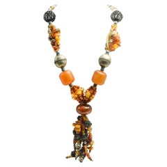 Grand collier bohème en bois d'ambre et verre avec pompon en forme d'os