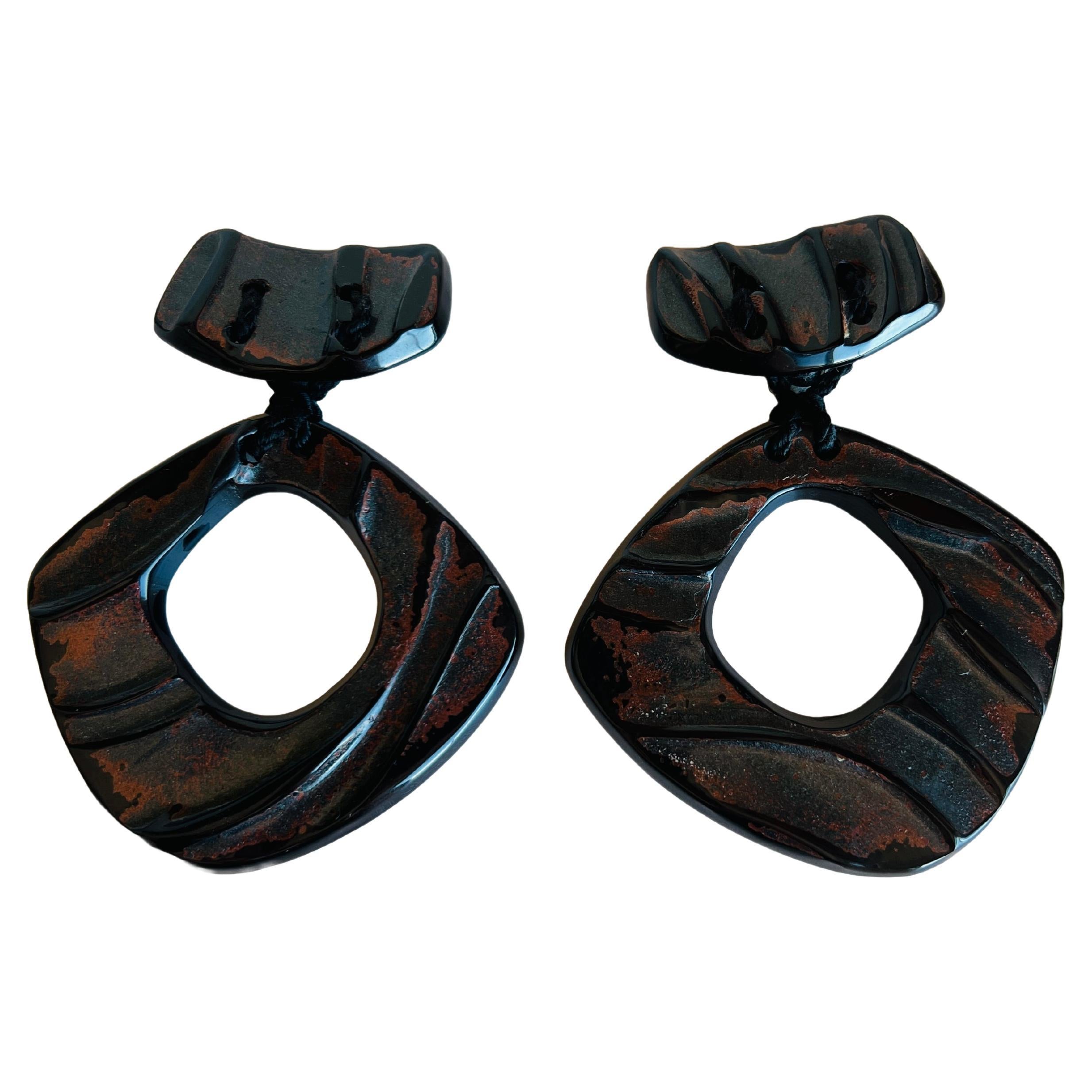 Step back into the bold and vibrant era of the 1980s with these striking and massive hoop clip earrings designed by the renowned duo Anne and Frank Vigneri. Known for their innovative designs and use of unconventional materials, Anne and Frank