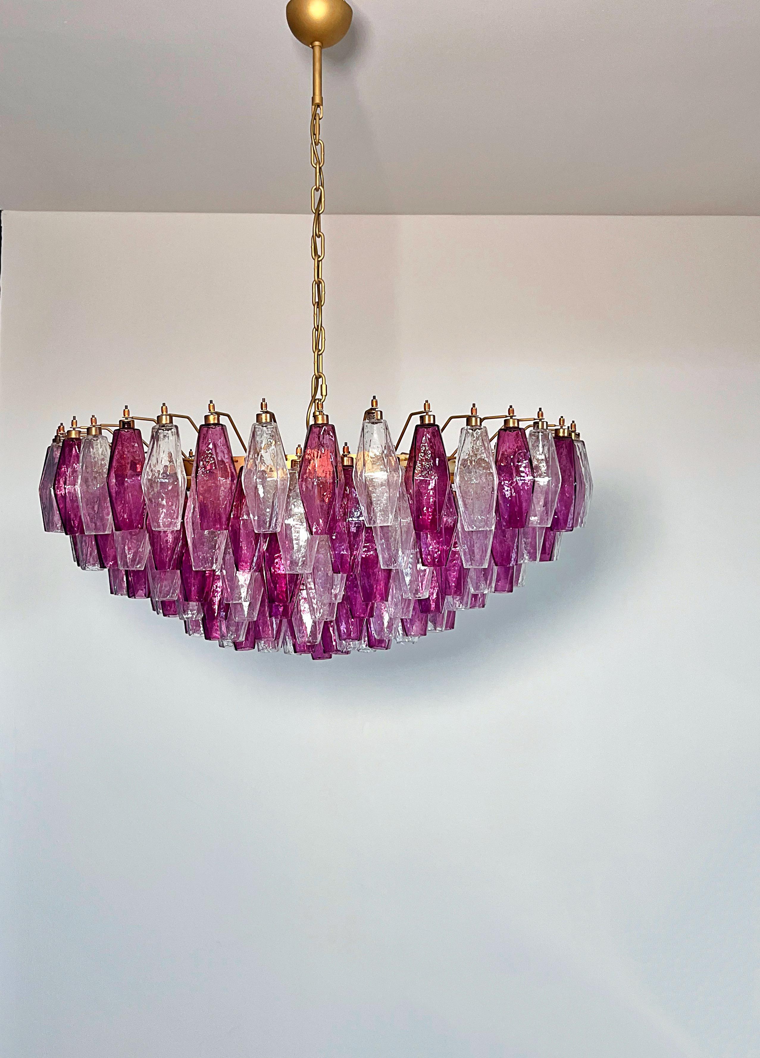 Enorme y colorida araña ecléctica de Murano al estilo de Carlo Scarpa con preciosos prismas de poliedro soplados a mano en un atrevido color fucsia, así como cristal transparente.
Estructura de la lámpara pintada en tono bronce dorado. Si lo