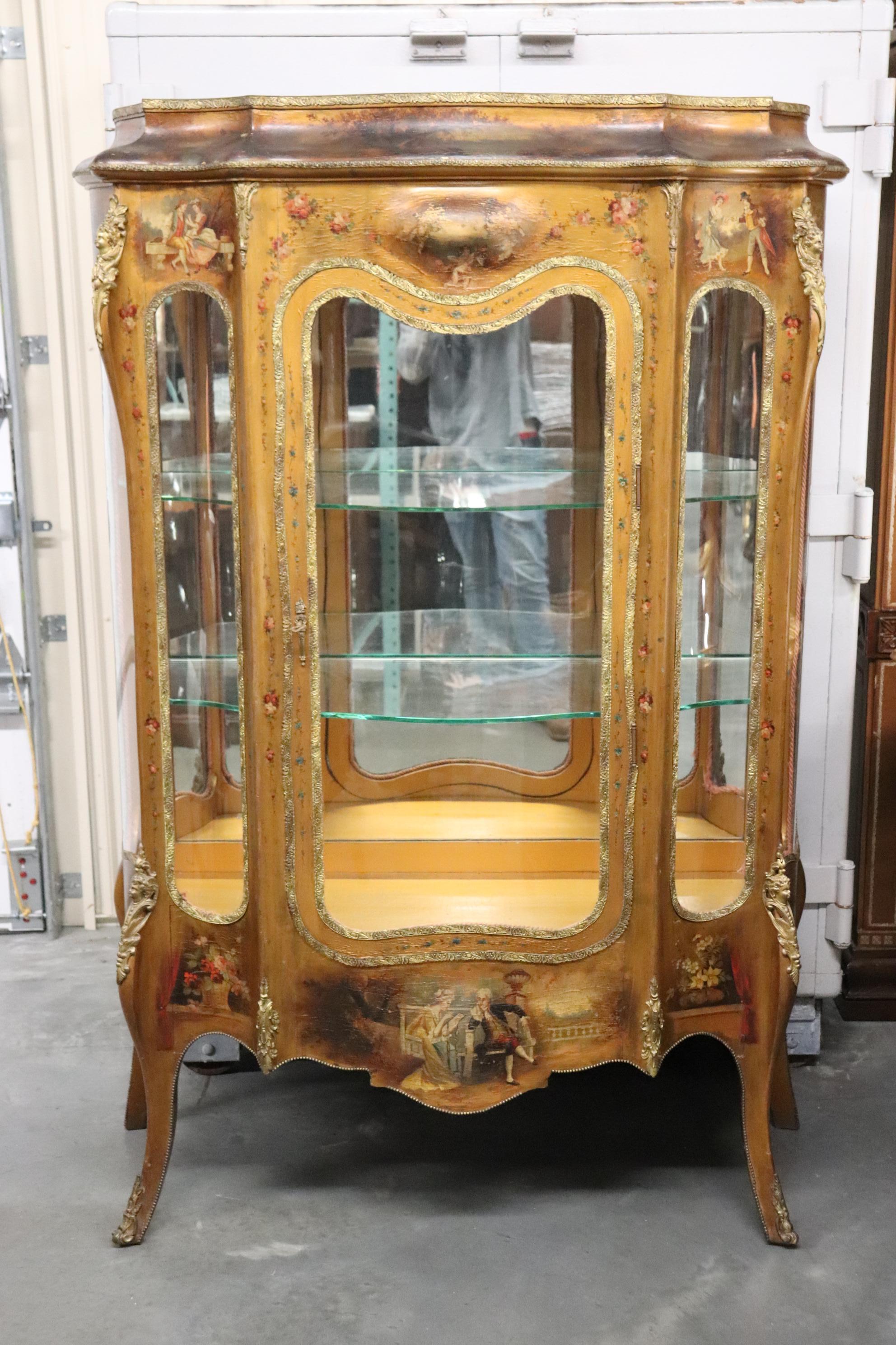 This is a fantasic Rococo style Italian-made gilded Vernis Martin china cabinet. The cabinet is lavshly gilded in genuine gold leaf and has beautiful exterly cast solid bronze figures and ormolu. The cabinet is extremely complex and offers plenty to