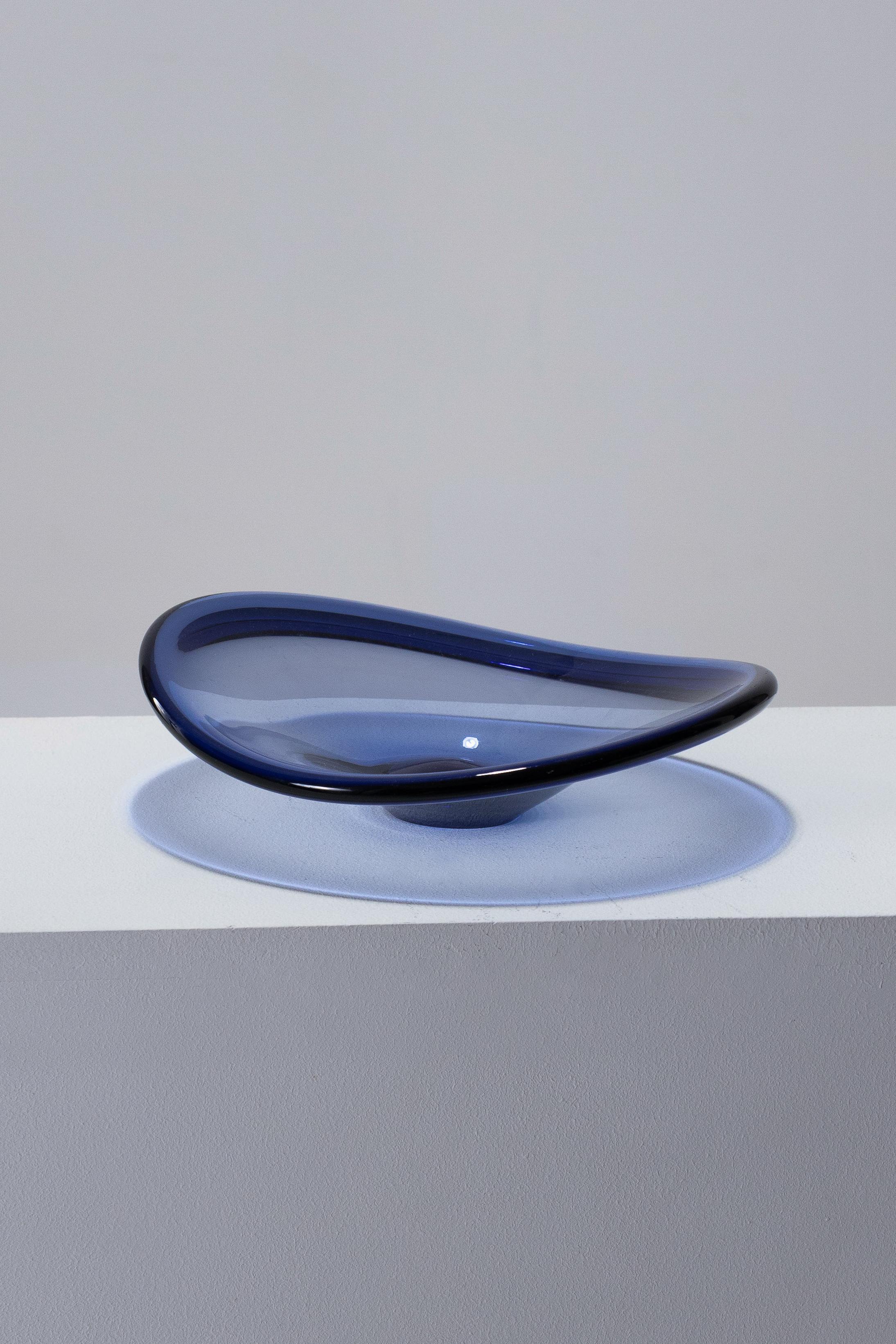 Grand bol en verre bleu épais du verrier suédois Holmegaard, années 1950. La lumière met en valeur la forme de ce bol creux en verre transparent teinté de bleu. Arrondi et légèrement incurvé, il repose sur une base circulaire. En parfait état.
DV2075