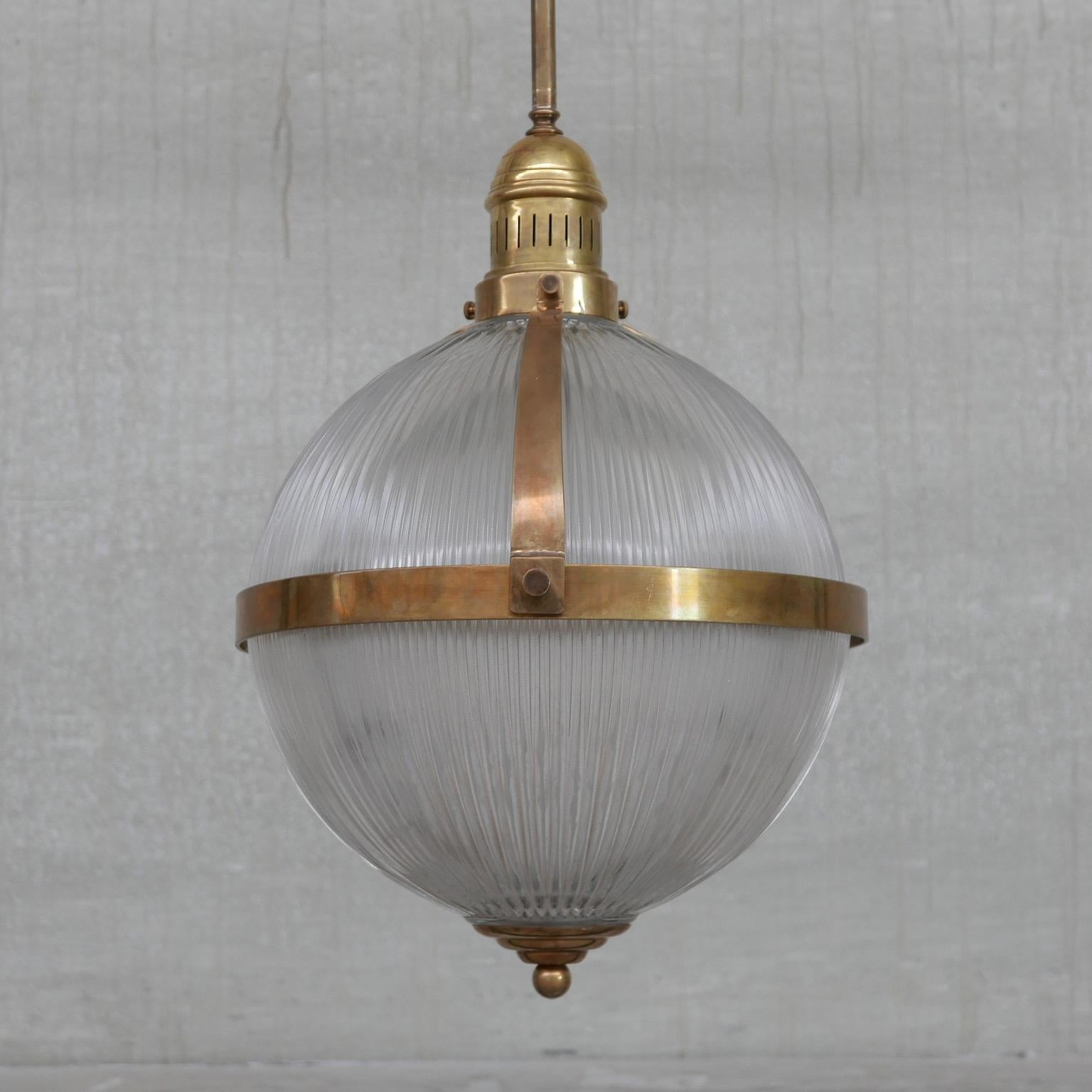 A mid to late 20th large pendant light. 

France, c1970s. 

Pressed glass in holophane style. 

Brass hardware in the form of a rim, gallery, long stem and finial. 

Very good quality.

One available. 

Re-wired and PAT tested.