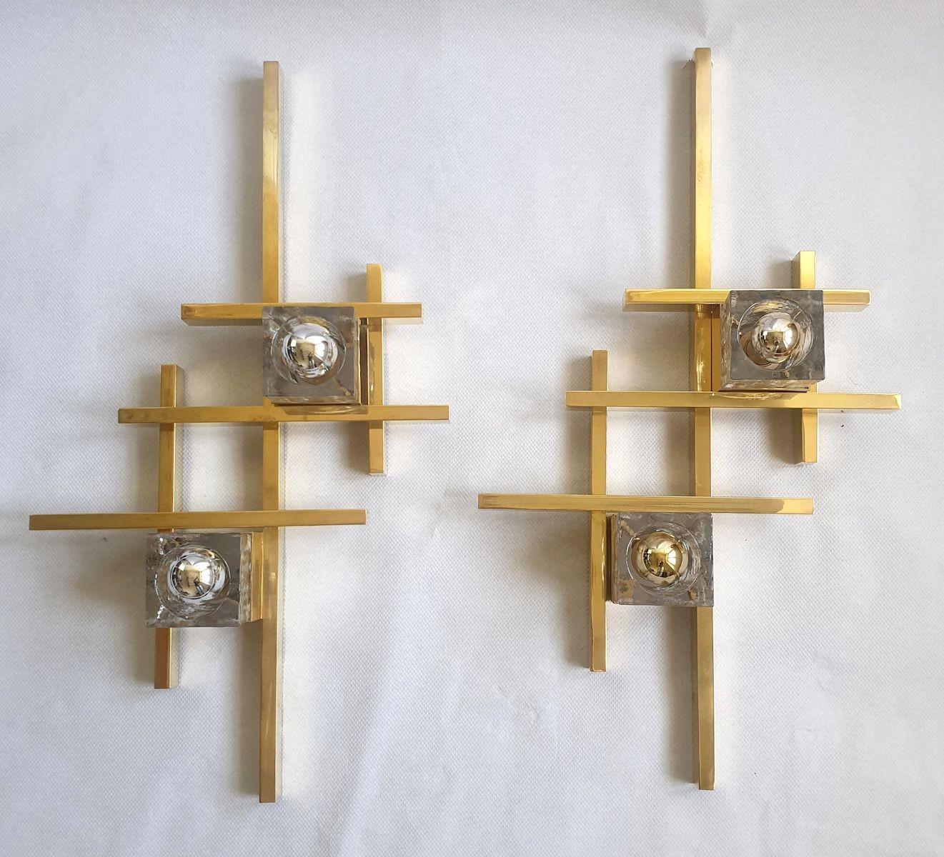 Pair of geometrical large sconces, attributed to Gaetano Sciolari, Italy circa 1970s.
The Mid-Century Modern pair of sconces are made of brass and two Murano clear square glasses, each nesting a light bulb.
The vintage pair has a geometrical
