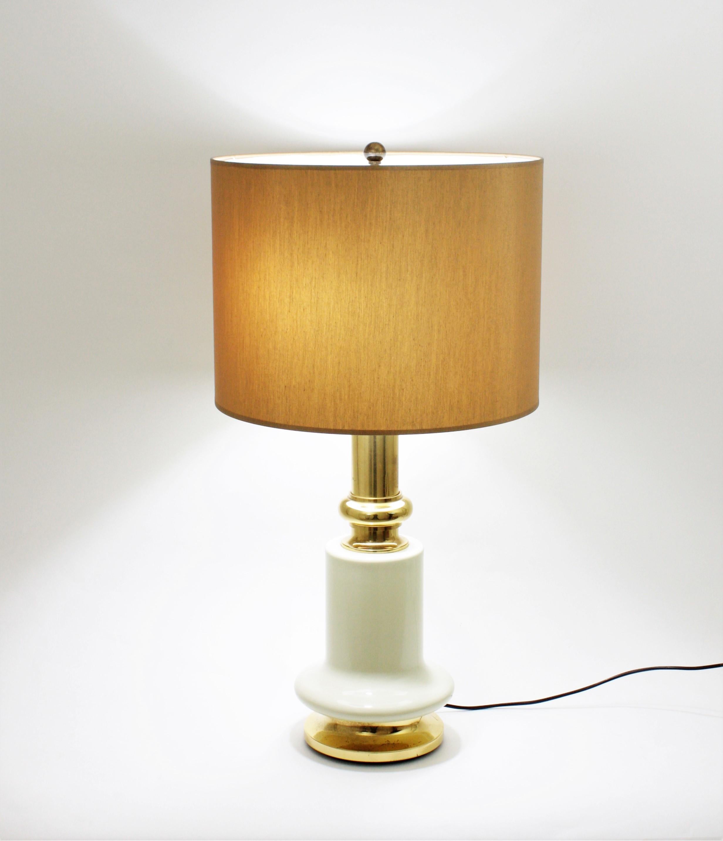 Beautiful polished brass and ivory lacquer Midcentury table lamp. Spain, 1960-1970.
This two-light table lamp combines polished brass at the bottom of the base and at the top with a central part lacquered in ivory color.
This lamp would be a good