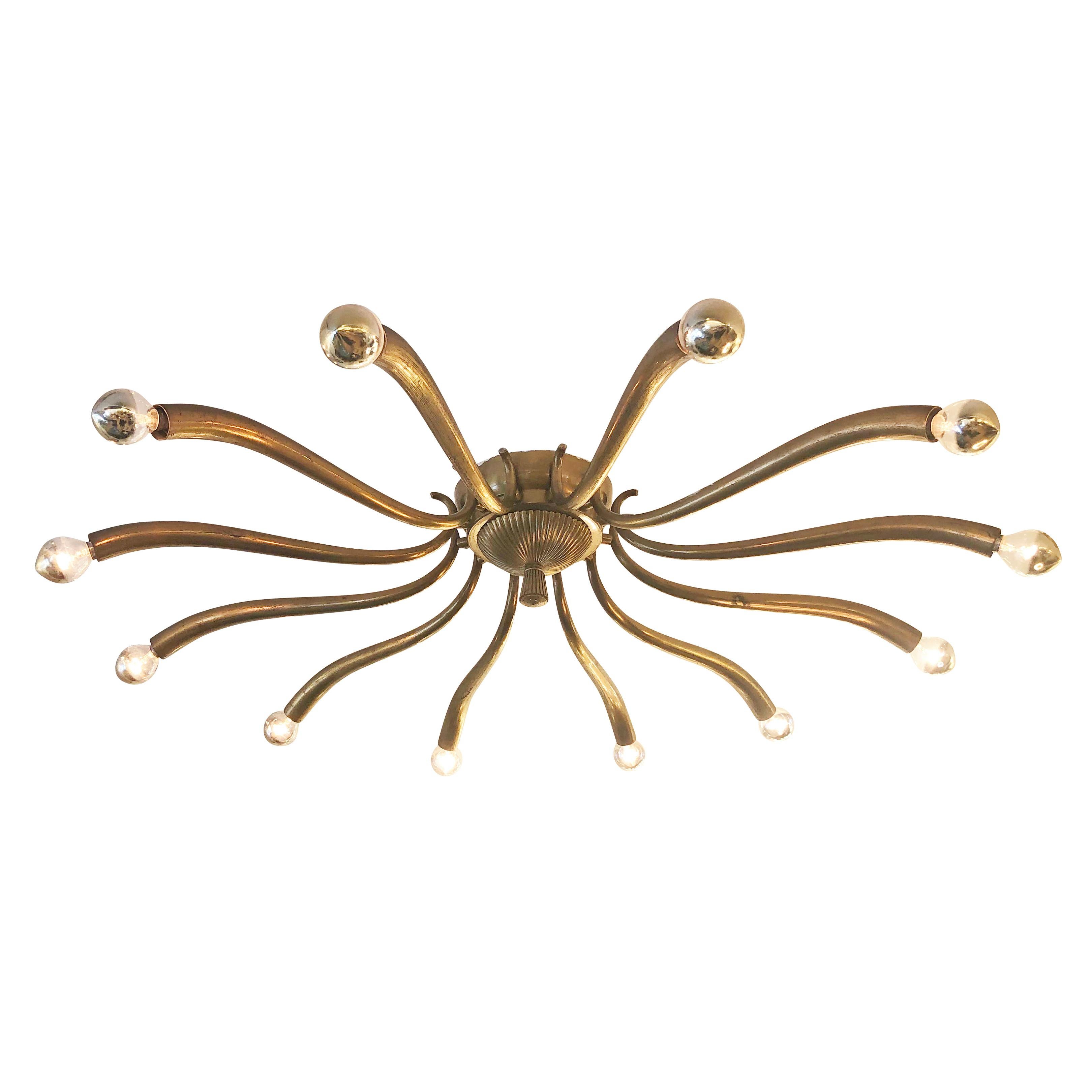 Large 1940s chandelier attributed to Guglielmo Ulrich with twelve sloping brass arms. Holds twelve candelabra sockets. Can be installed as a flush mount or on a stem.

Condition: Excellent vintage condition, minor wear consistent with age and use