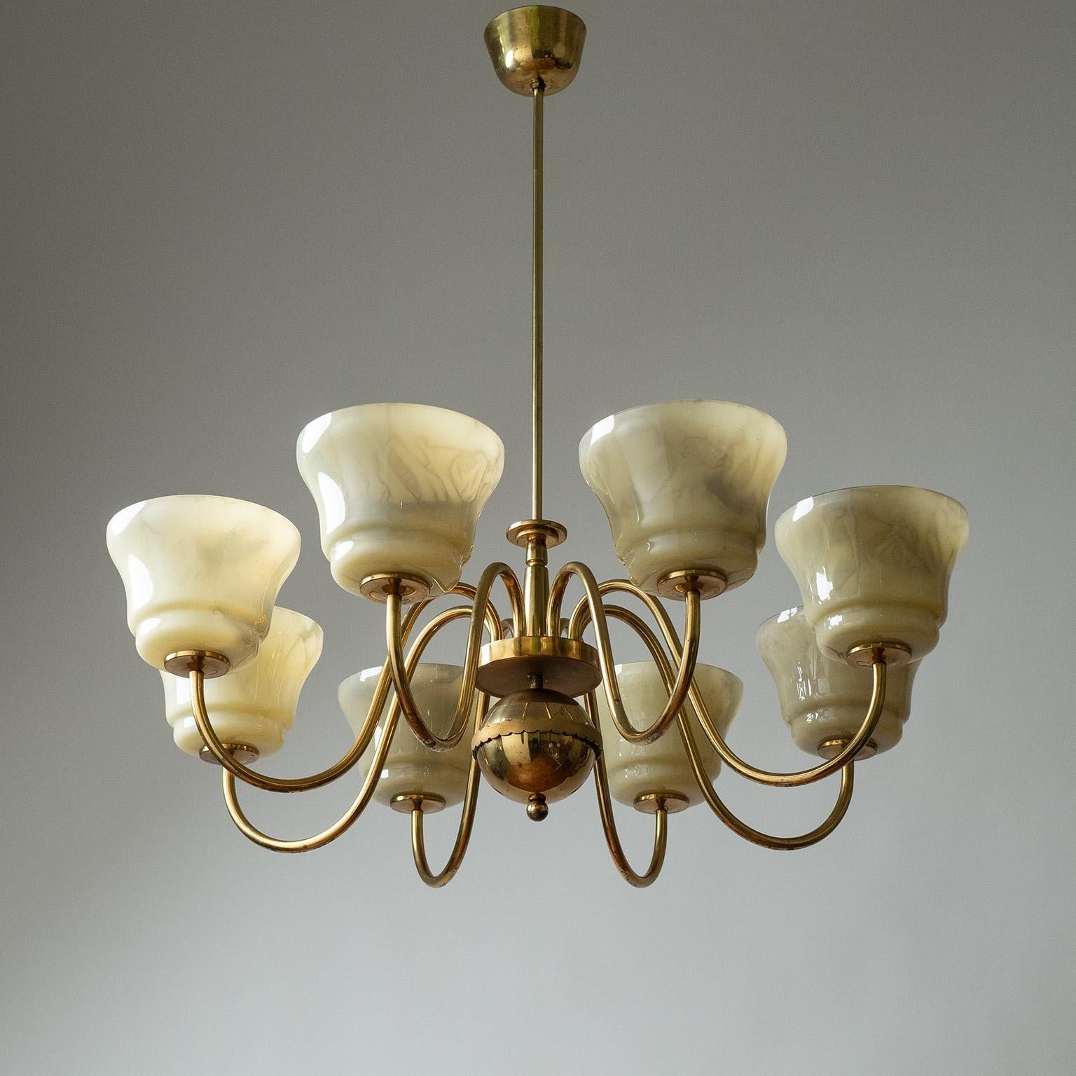Large eight-arm brass chandelier with enameled glass diffusers from the 1940s. Elegantly curved brass arms with a nicely styled centerpiece. The blown glass diffusers are enameled on the inside for a marbled effect (comes with two spare glasses).