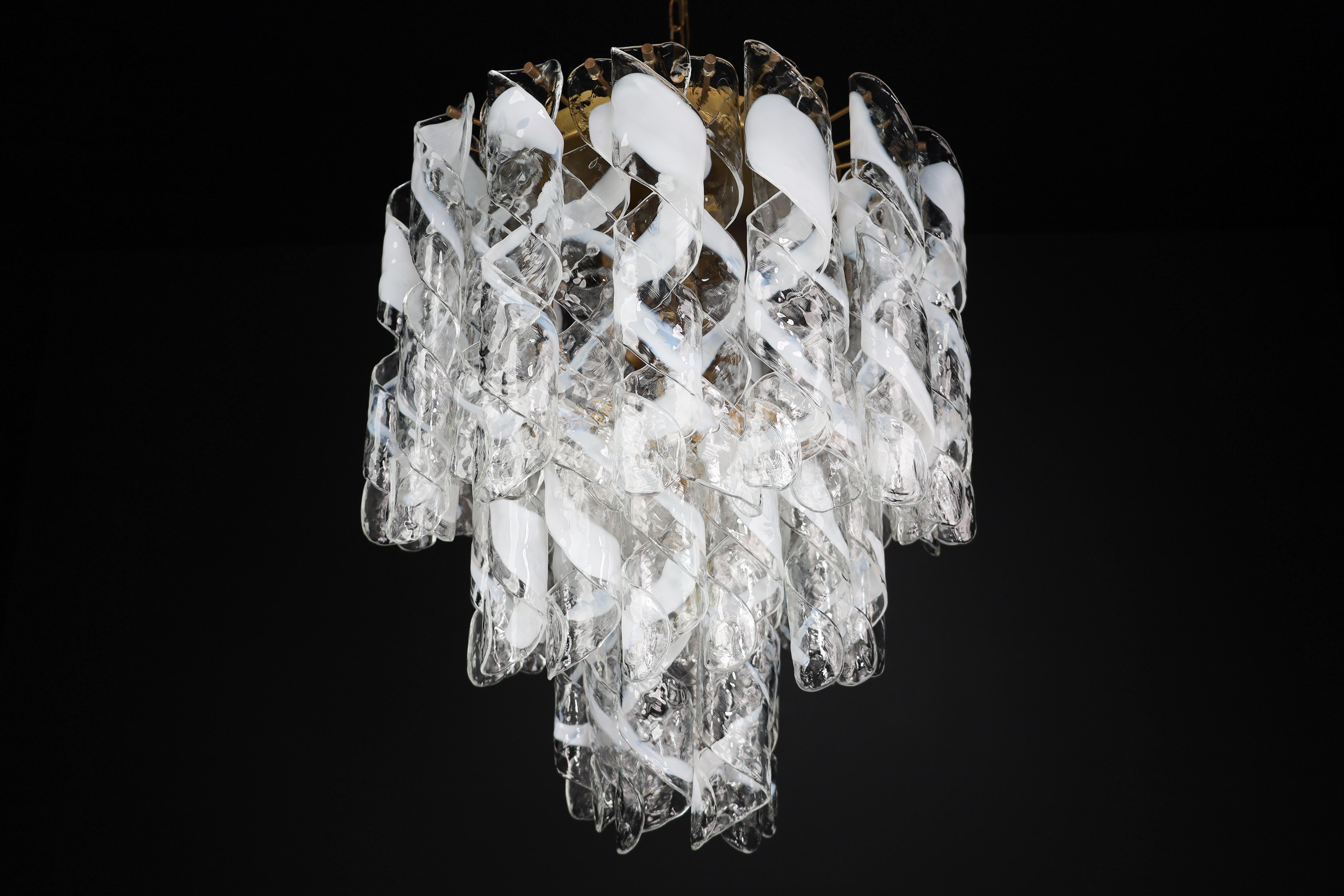 Large brass chandelier with 'Torciglioni' Glass by Mazzega, Italy 1970s.

Fabulous large brass chandelier attributed to Murano brand A.V Mazzega made in Italy 1970s. The chandelier has spiral-shaped glass pieces (called 'Torciglioni') with white