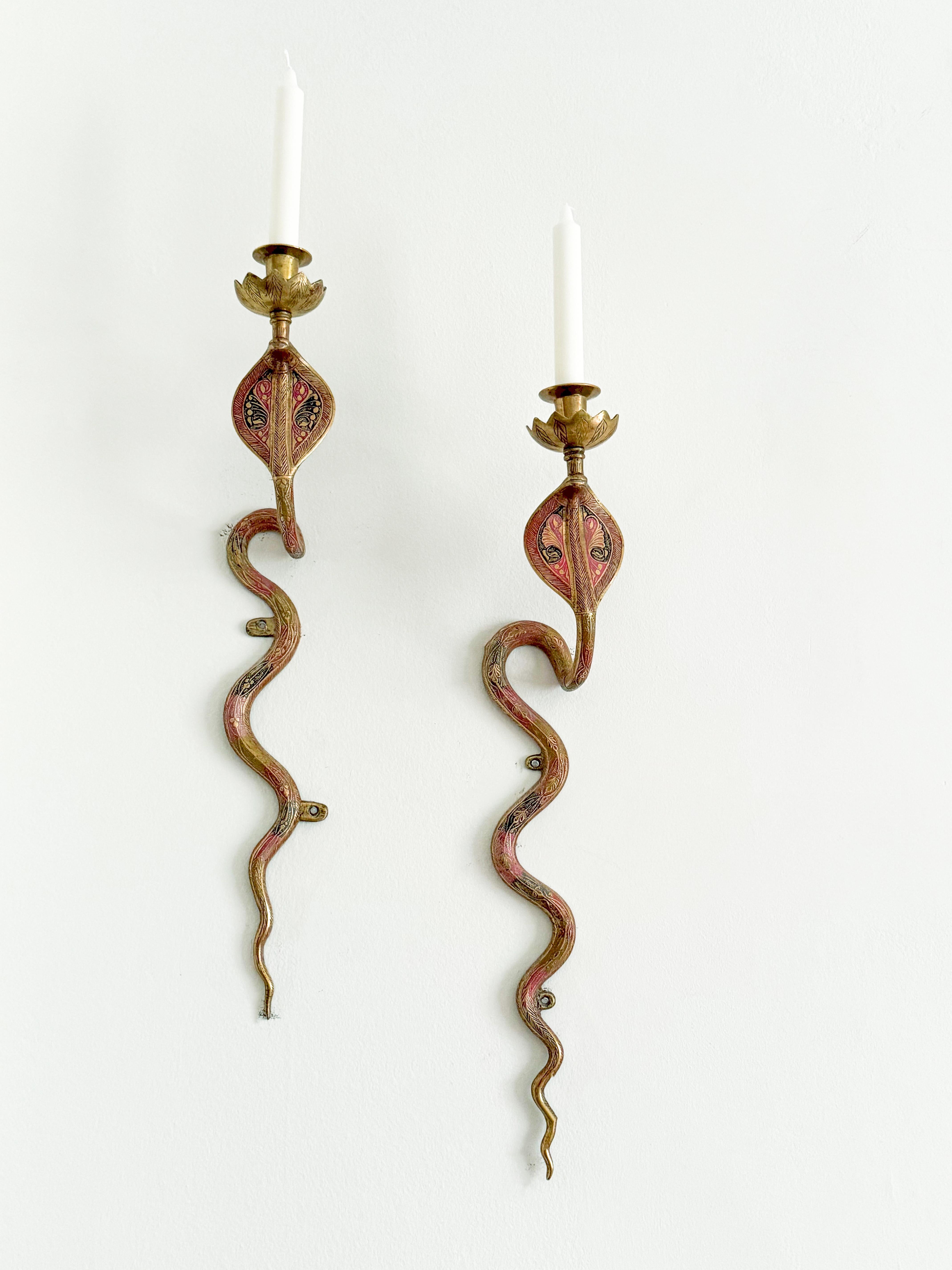 Enhance your decor with this rare pair of large brass cobra snake candle wall sconces. Each sconce features a gracefully coiled cobra, intricately detailed with vibrant brass accents. Designed to hold candles, they cast a warm, inviting glow, adding