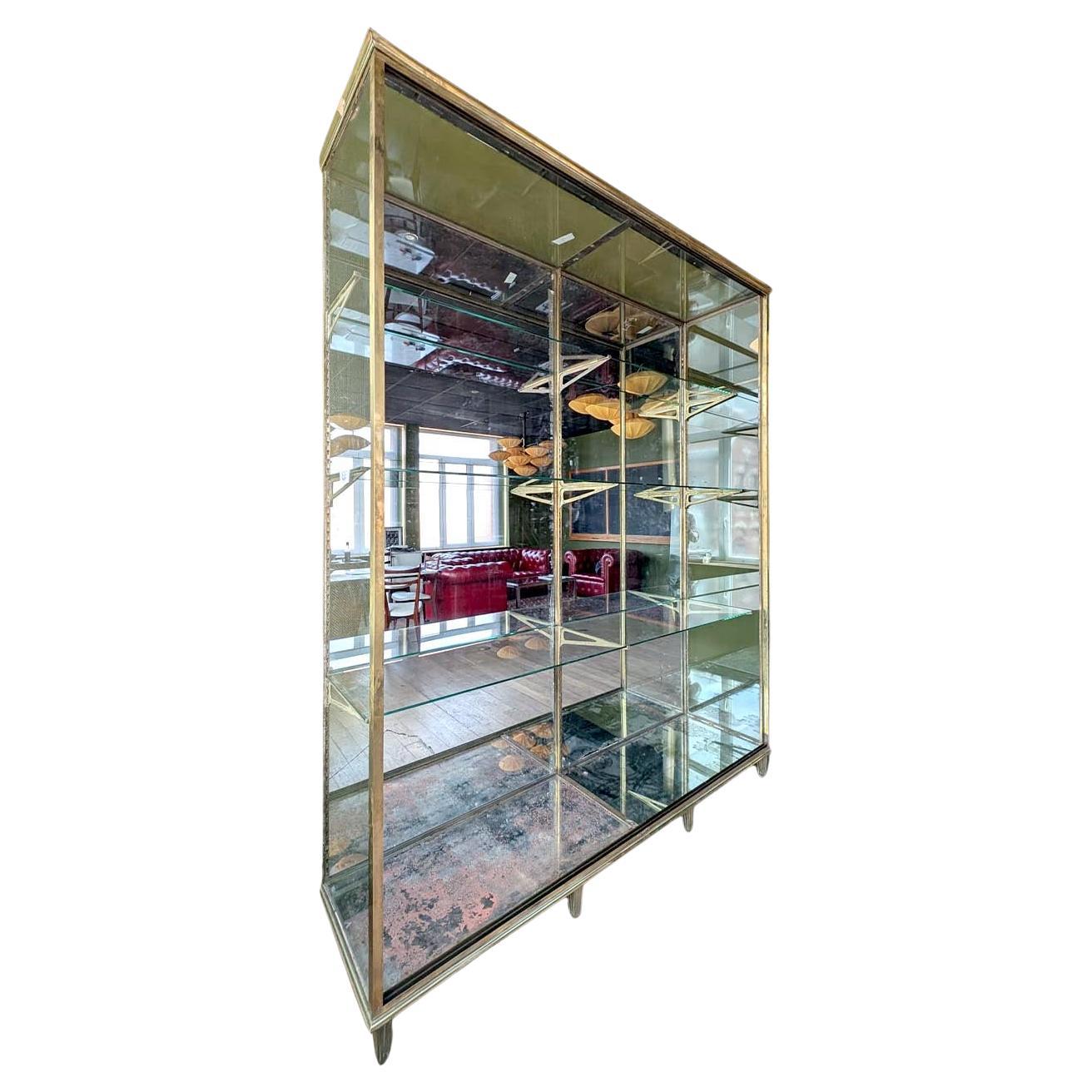 Prächtige Vitrine aus patiniertem Messing, die den renommierten Ateliers Modernes d'Étalages in der Rue de Laghouat 15 in Paris zugeschrieben wird. Dieses seltene Stück vereint raffinierte Handwerkskunst und funktionale Eleganz und eignet sich ideal