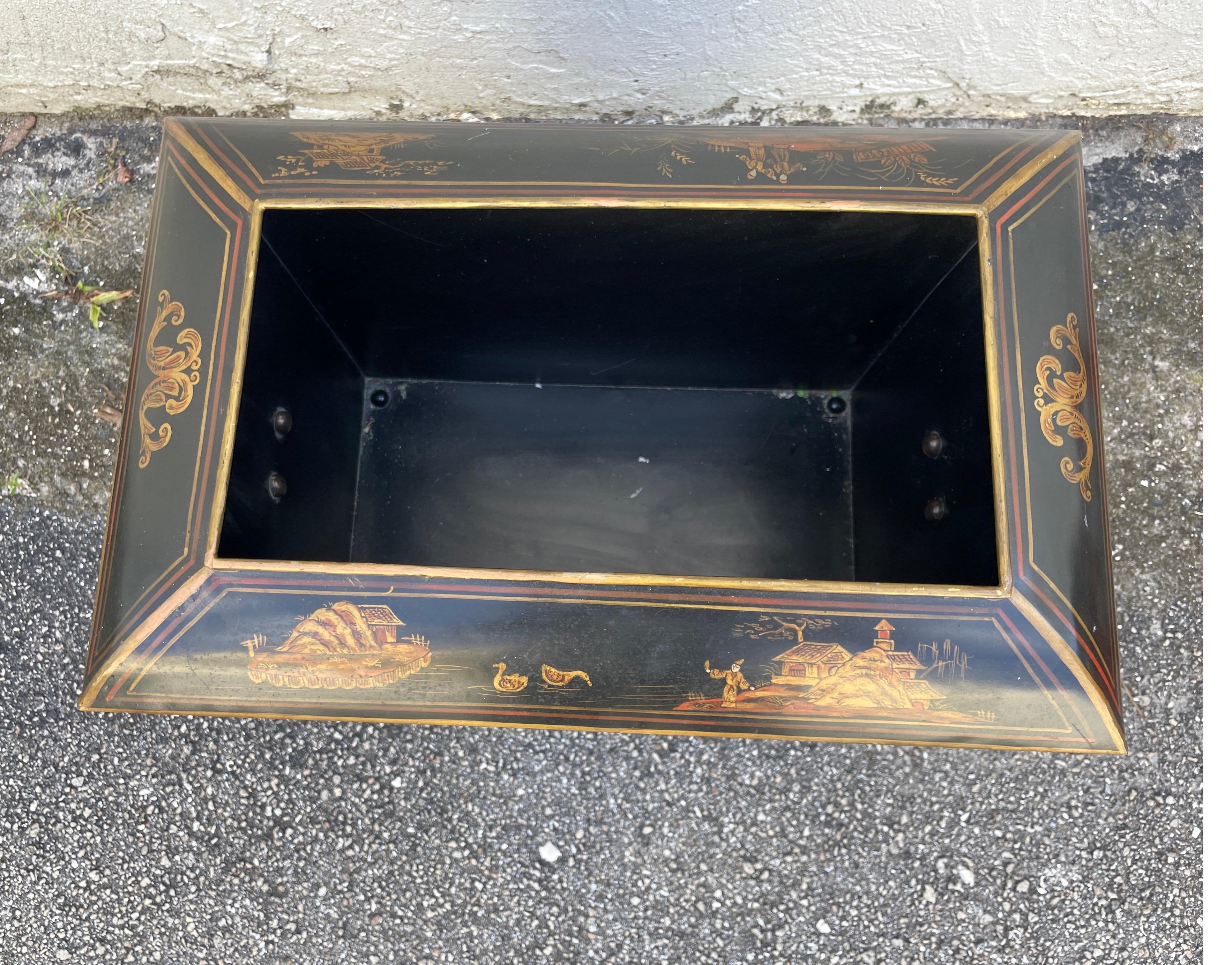 Large Black Tole Chinoiserie planter with decorations on sides and lion head rings.  Raised on large brass paw feet.
