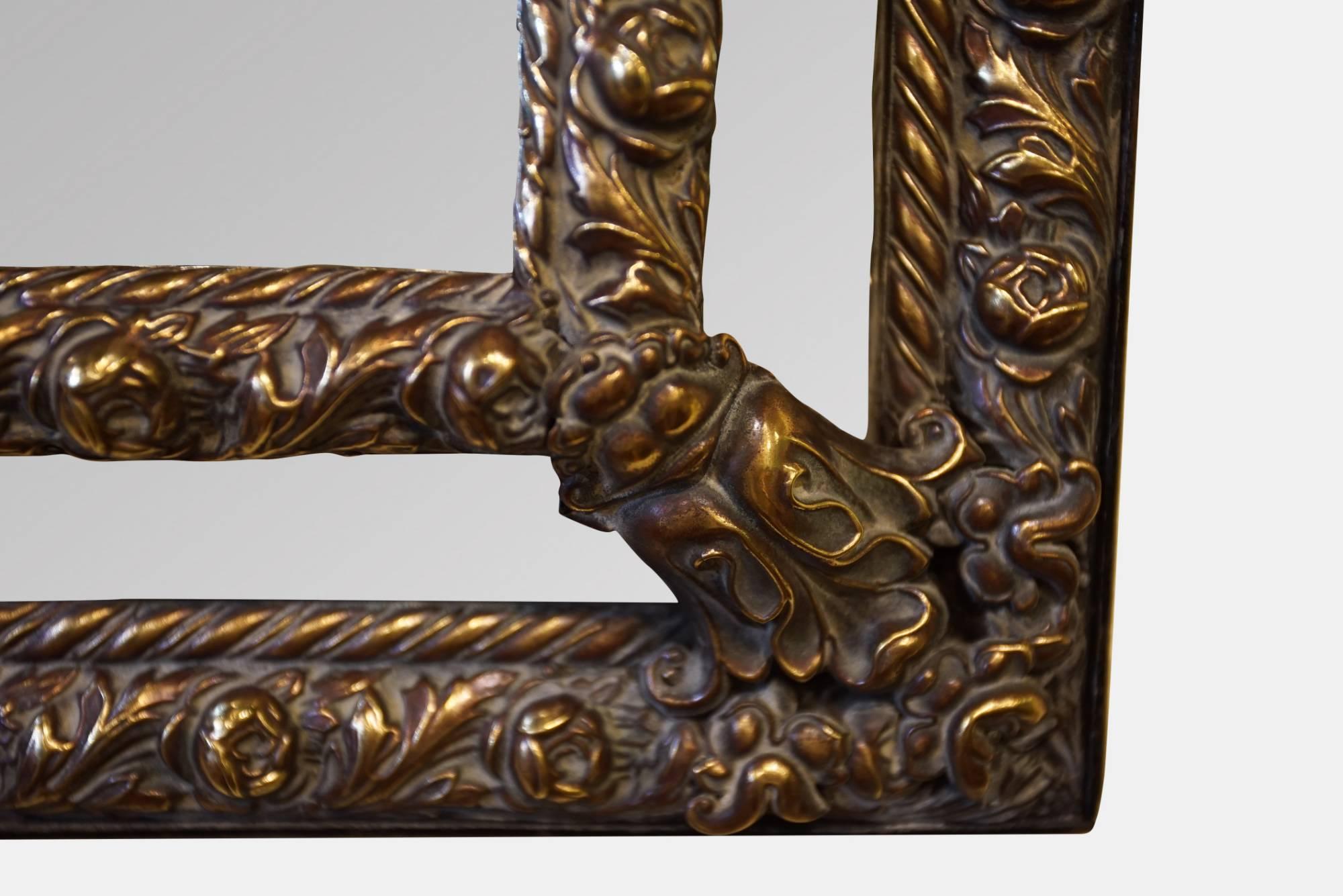 A large decorative French brass framed border mirror with original glass,

circa 1870.