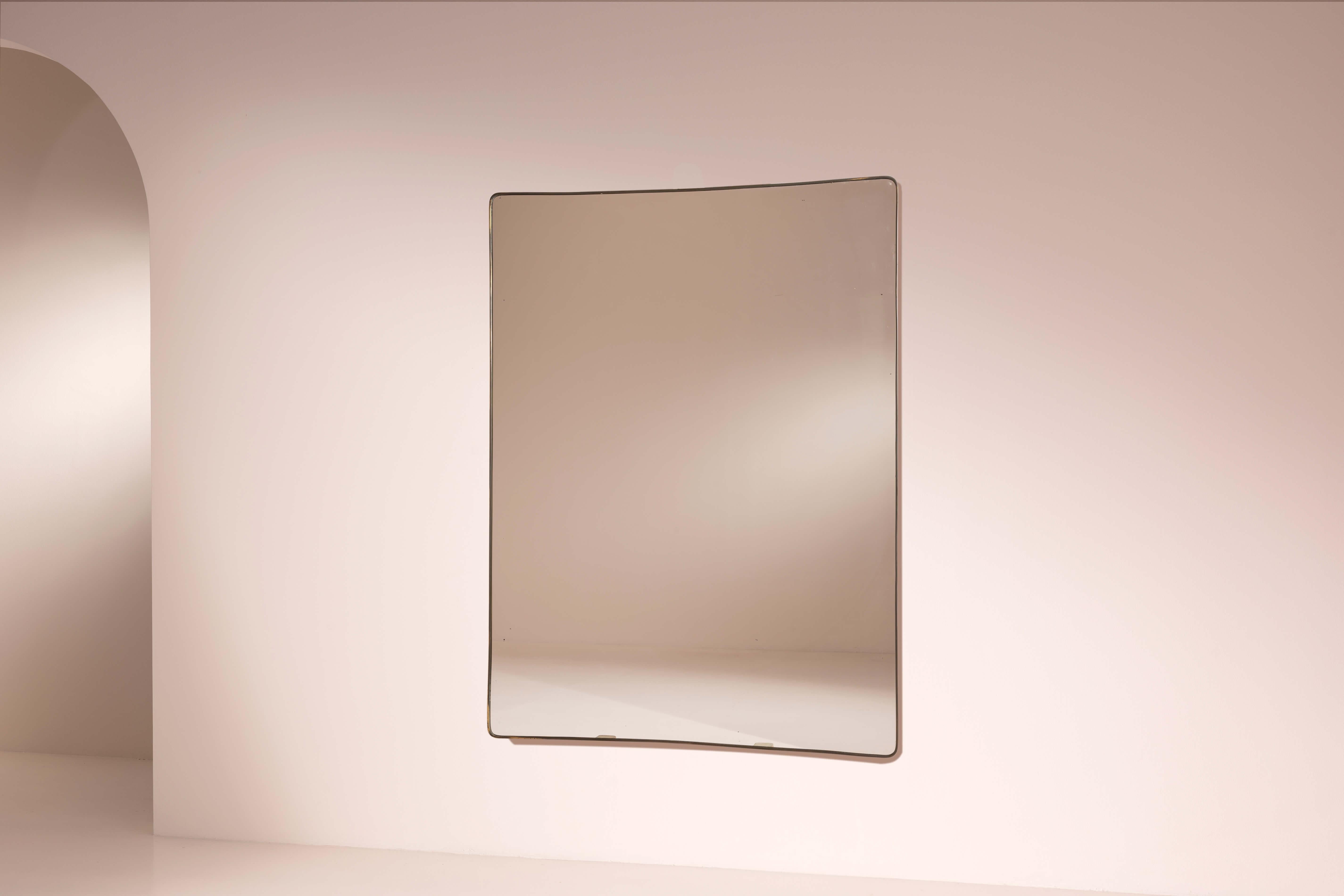 A large and elegant brass-framed mirror with original mirrored glass, rounded rectangular shape, Italian manufacture, 1950s.
This elegant, large-scale wall mirror—gracefully shaped with rounded corners—is ideal for enhancing an entryway, bedroom, or