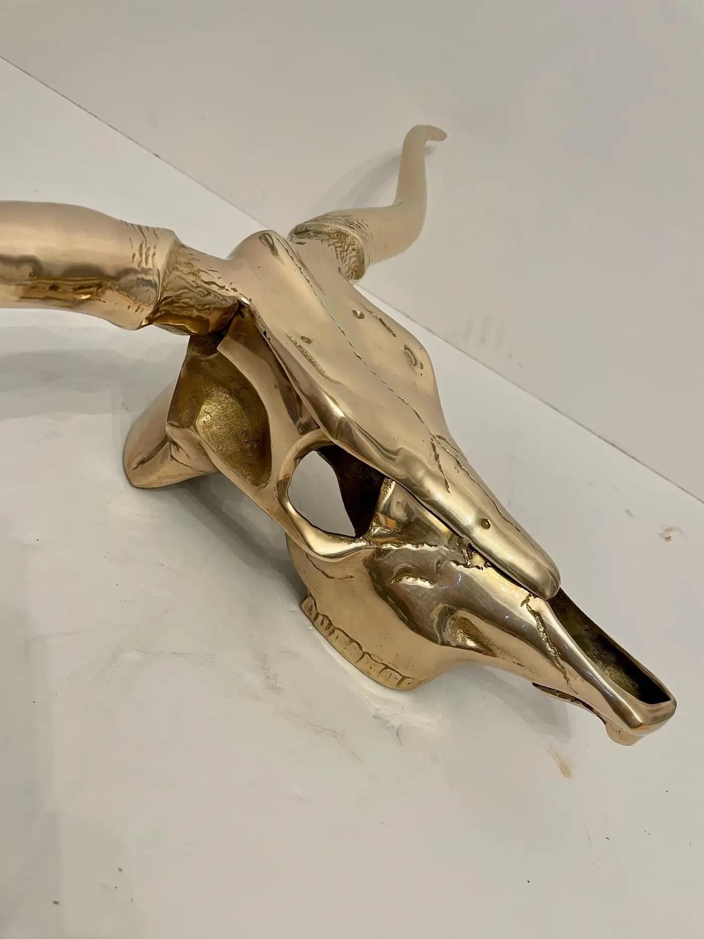 The Hollywood Regency style brass longhorn wall sculpture is a striking and glamorous piece of art that epitomizes the opulence and drama of the Hollywood Regency design era. Crafted from lustrous brass, this wall sculpture features a longhorn