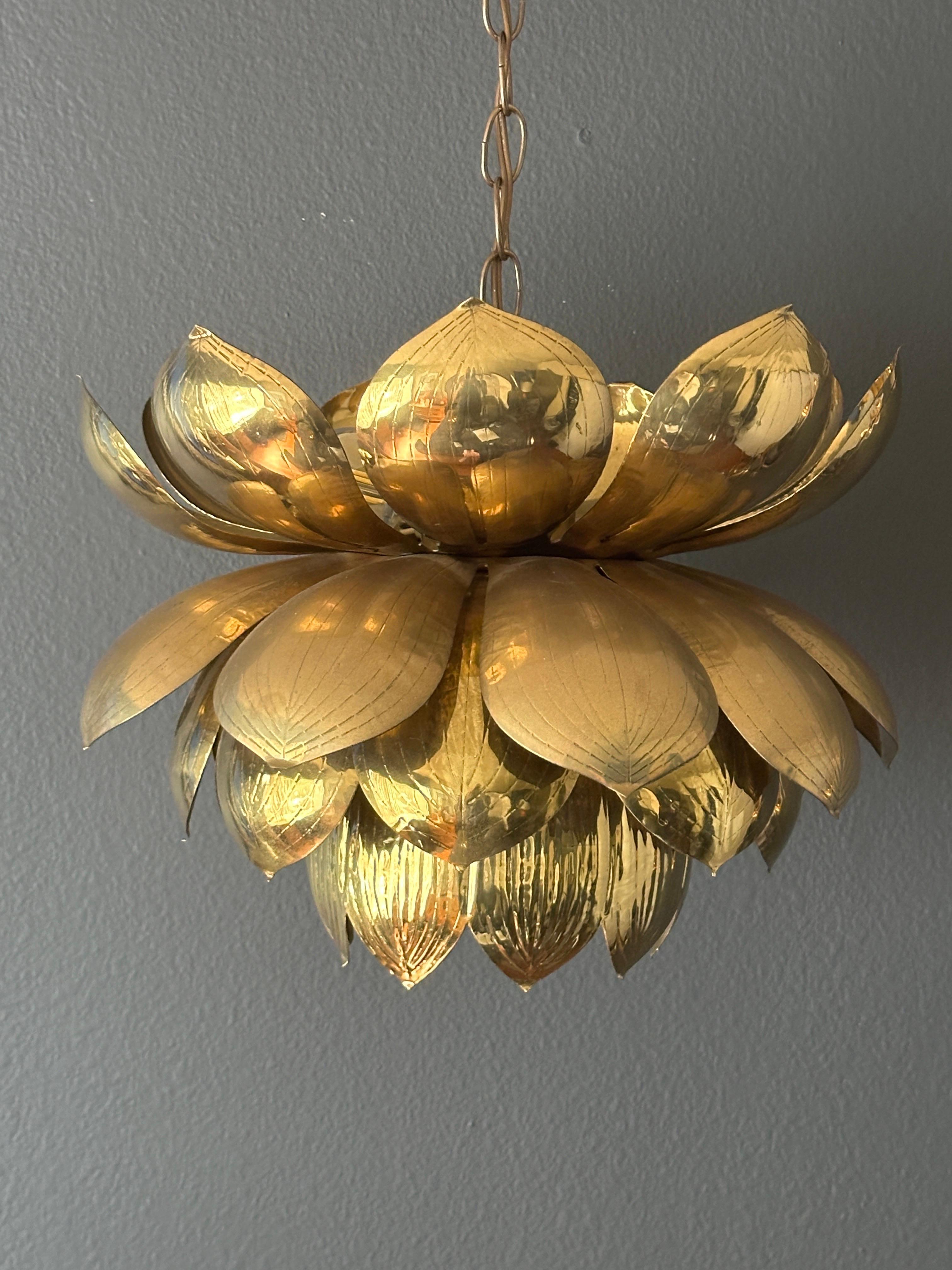 Large natural patinated brass lotus pendant by Feldman Lighting. Pendant has three candelabra base bulbs on top and one regular base up to 60watt bulb on bottom. Chain is 20” long.
