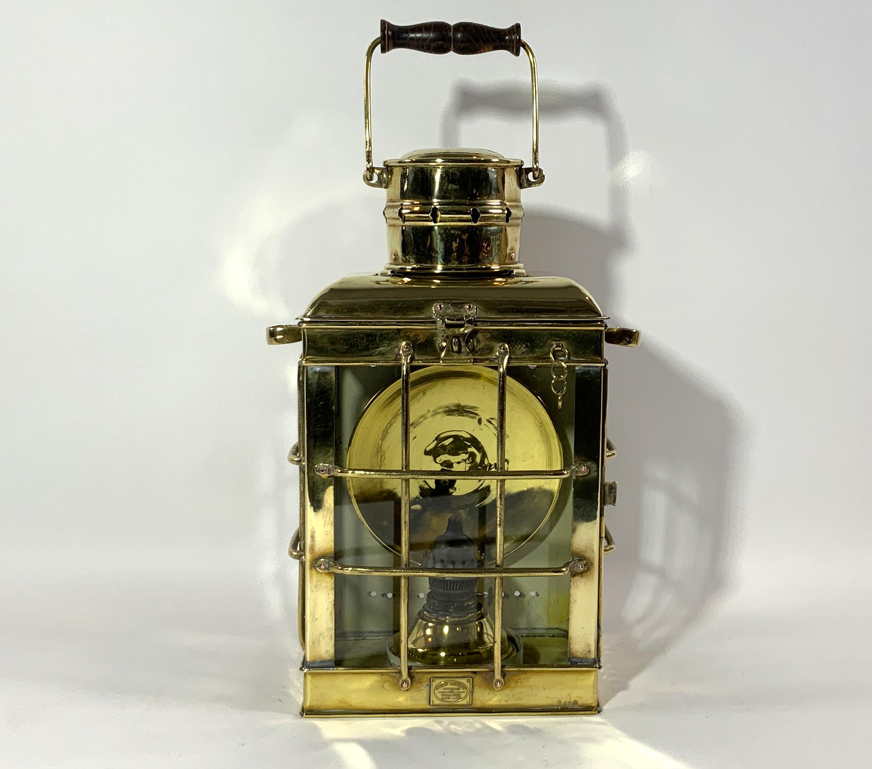 Solid brass ships lantern with makers badge from Davey of London. Approved 1924 Regulation marine lamp. There are three glass panels with protective brass grates. Vented chimney with hasp. Quite heavily built. Oil burner and rear reflector. Circa
