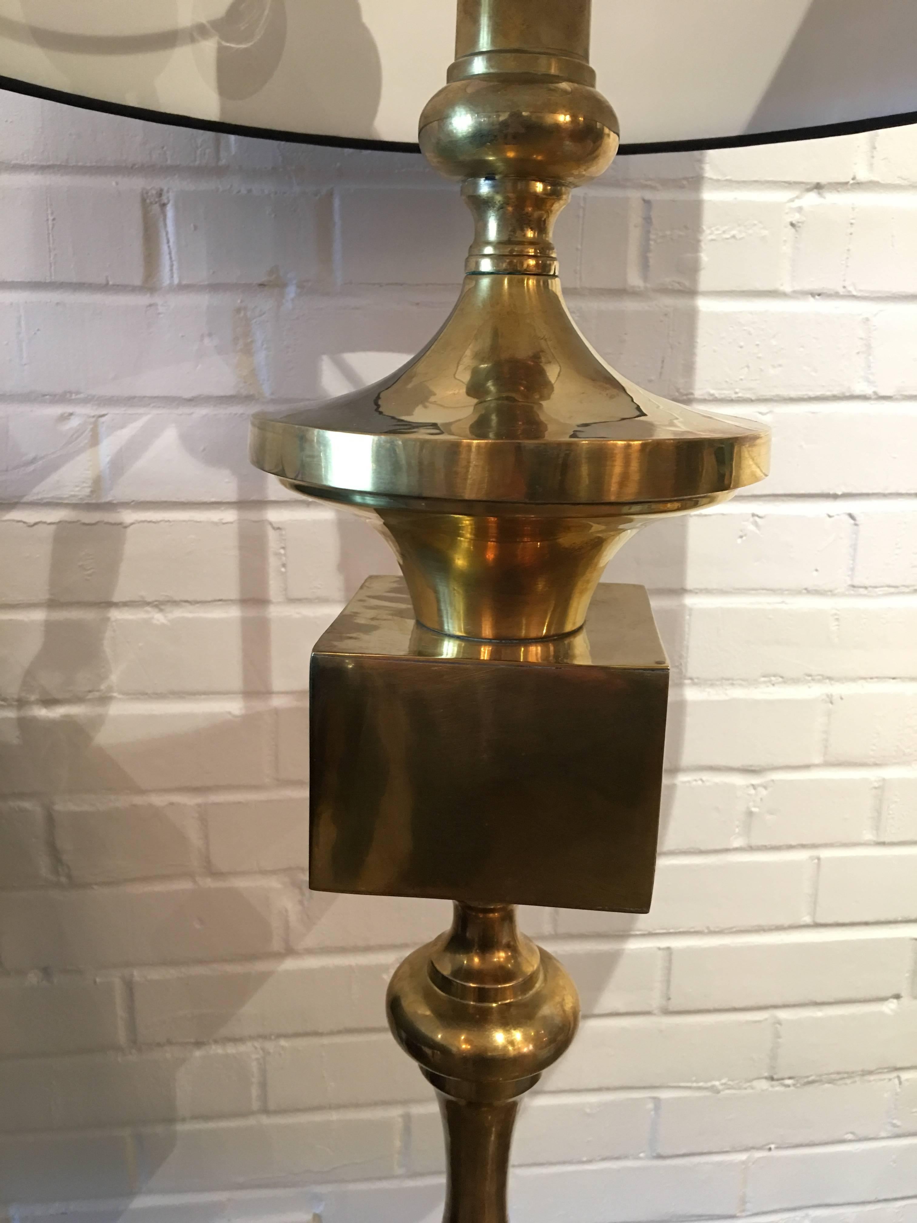 This large brass sculptural midcentury lamp is quite impressive. It has a new black linen lamp shade. The lamp holds three lightbulbs with each one lit independently.
