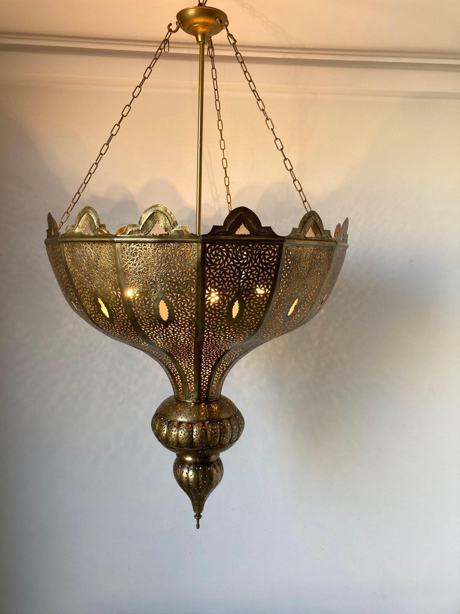 Lustre mauresque marocain surdimensionné en laiton filigrané et ajouré de style Alberto Pinto.
Cet exquis luminaire marocain est délicatement fabriqué à la main et ciselé avec un fin filigrane métallique ajouré et orné d'un verre laiteux.
Finition