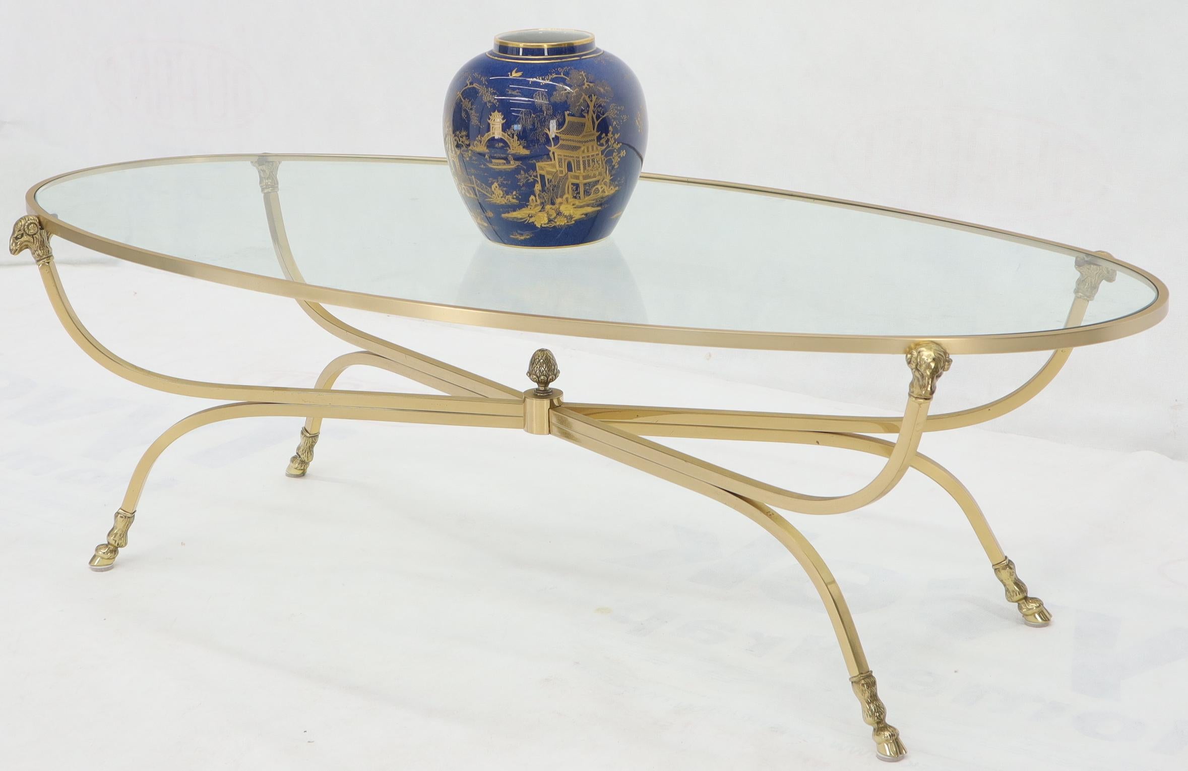 Large solid brass oval coffee table with rams head finials and hoof feet. Made in Italy.
