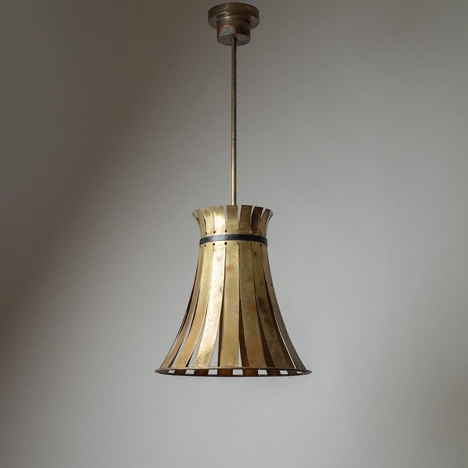 Large brass pendant from the 1940-1950s.The oversized cone-shaped body is made from a single polished sheet of brass, cut into strips that are attached to a brass ring on the bottom. Heavy patina throughout with a single original brass E27 socket