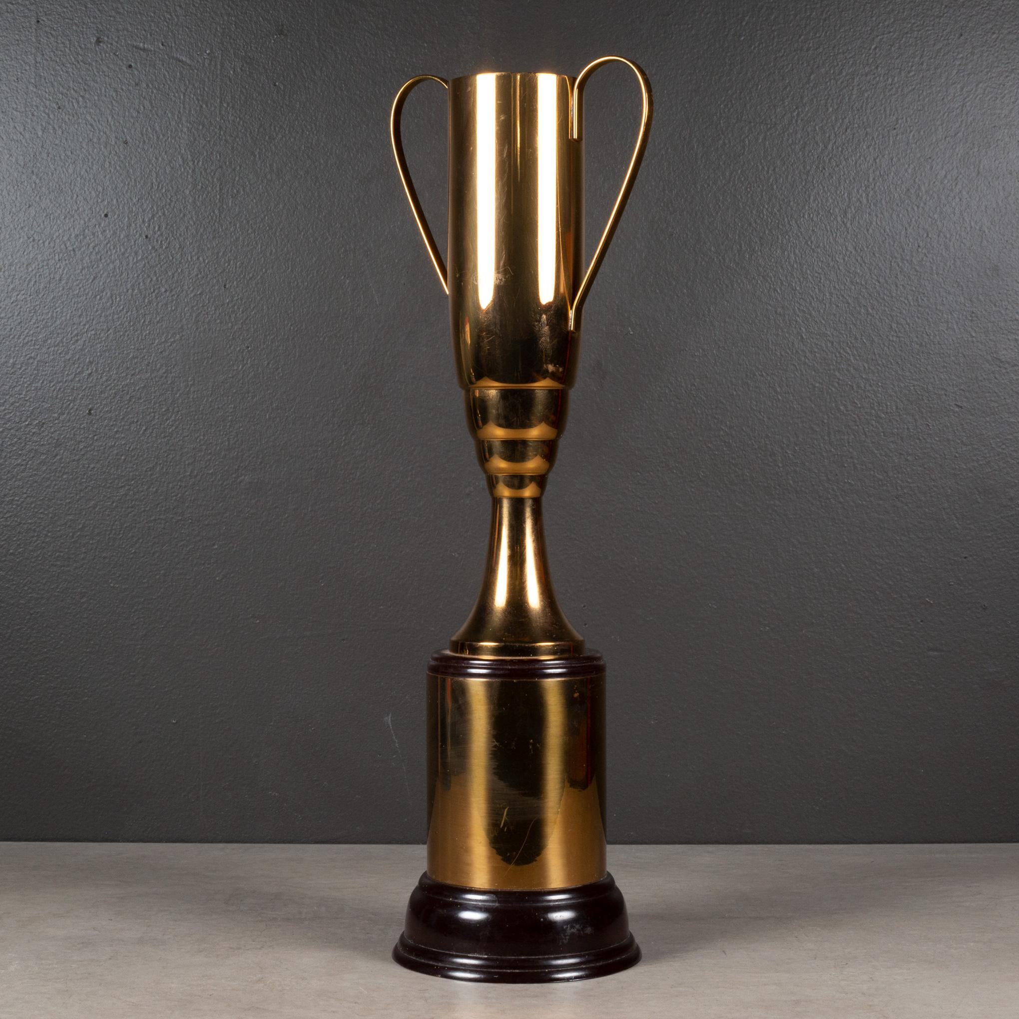 ABOUT

A large brass plated cup trophy with a Bakelite base and Bakelite collar. 

Shown with life size handle model for scale. 

    CREATOR Trophy Craft Co.
    DATE OF MANUFACTURE c.1940-1950.
    MATERIALS AND TECHNIQUES Brass Plate, Bakelite.
 