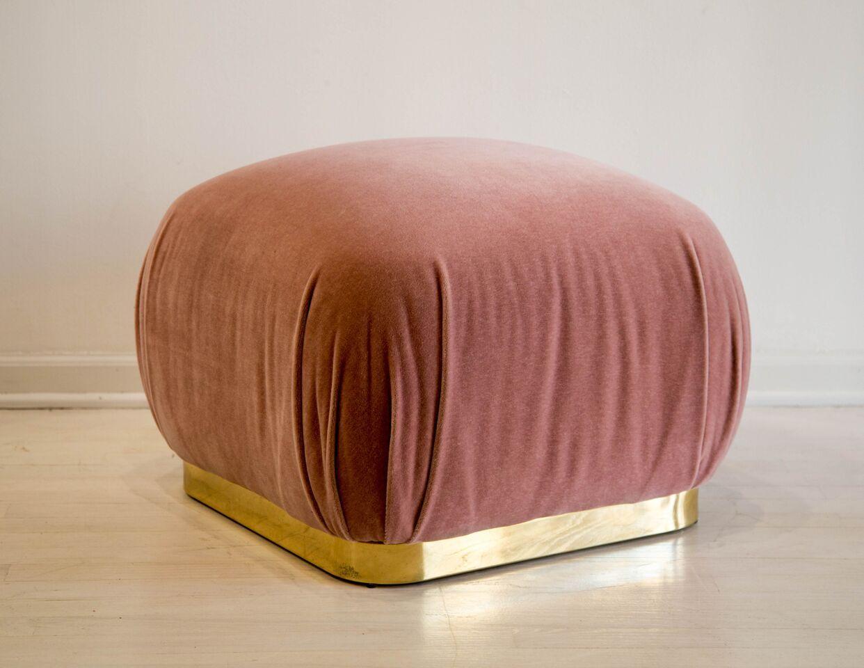 A large 1980s “souffle” shaped pouf, used commonly as an ottoman. This features a brass plinth base with new dusty rose mohair upholstery.
 