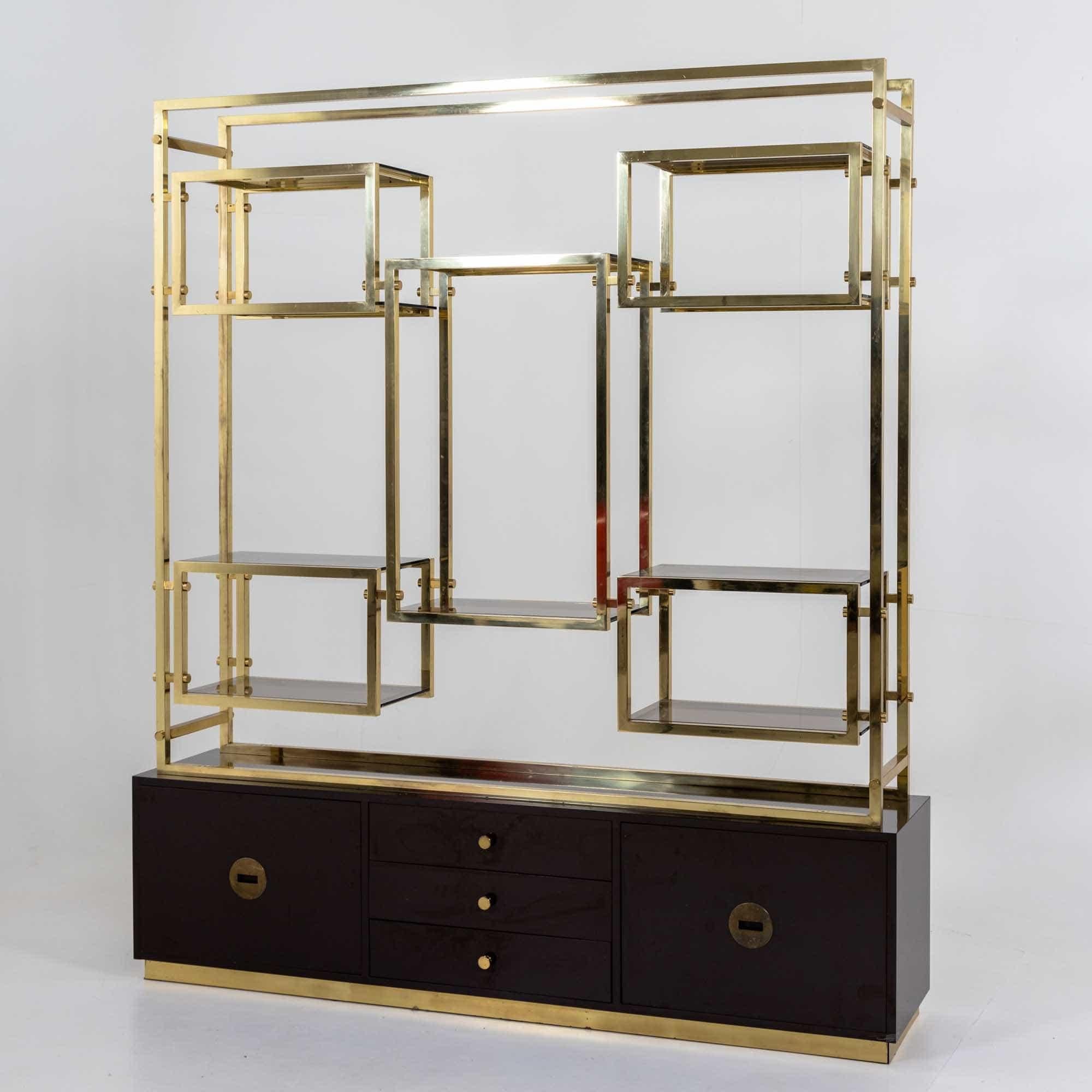 Large room divider shelf made of brass with a dark brown lacquered base with three drawers and two doors. The symmetrically designed shelf unit is fitted with smoked glass shelves and has a shelf depth of 32.5 cm.