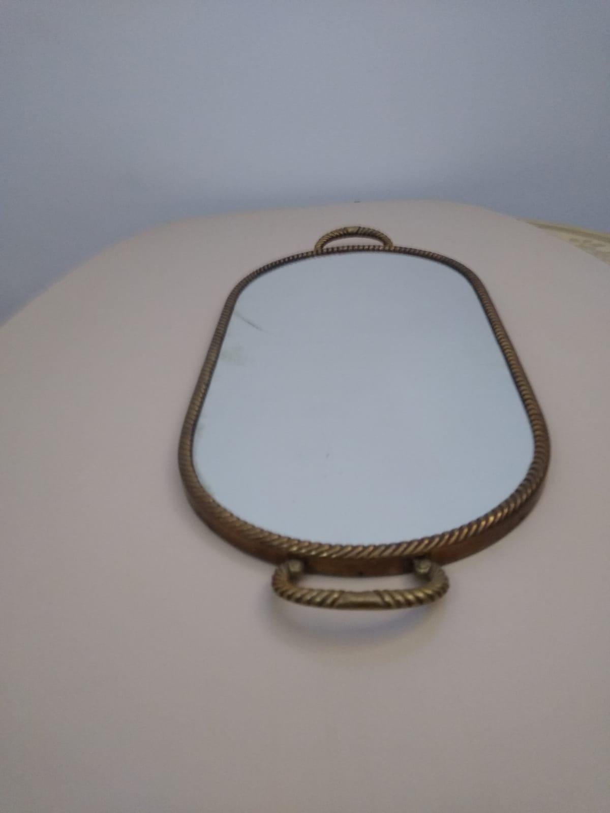 Fine and elegant oval shape serving tray made of brass with beautiful handles and mirrored glass top. Made in Italy in the 1950s.
