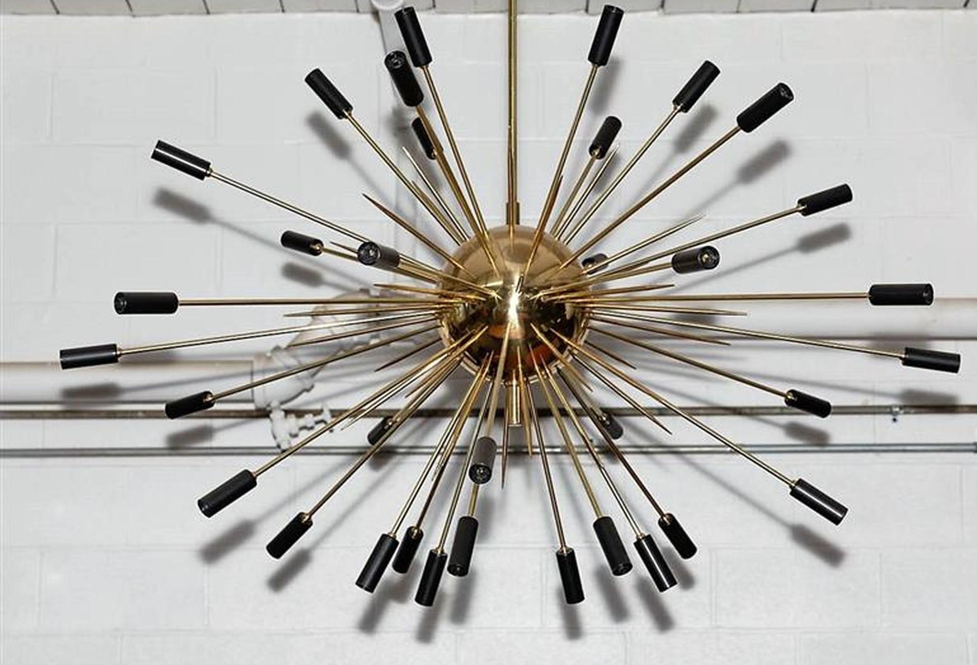 Large scale Italian light fixture reminiscent of an exploding star with black tips. Brass rods--both lit (34 candelabra bulbs) and speared--shoot out of a brass core. High-quality, hand made piece by Fedele Papagni Milano.
Wired for the US