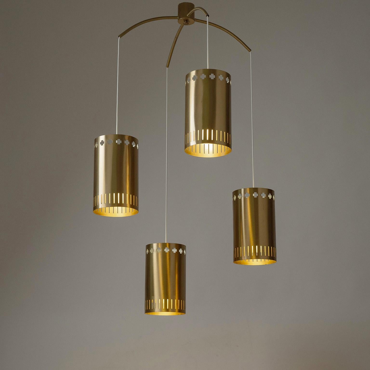 Raro grande lampadario a sospensione svedese in ottone di Boréns Borås degli anni '60. Unità a soffitto minimalista con quattro cilindri in ottone di grandi dimensioni (circa due galloni di volume ciascuno) con grandi ritagli a forma di croce. Prese