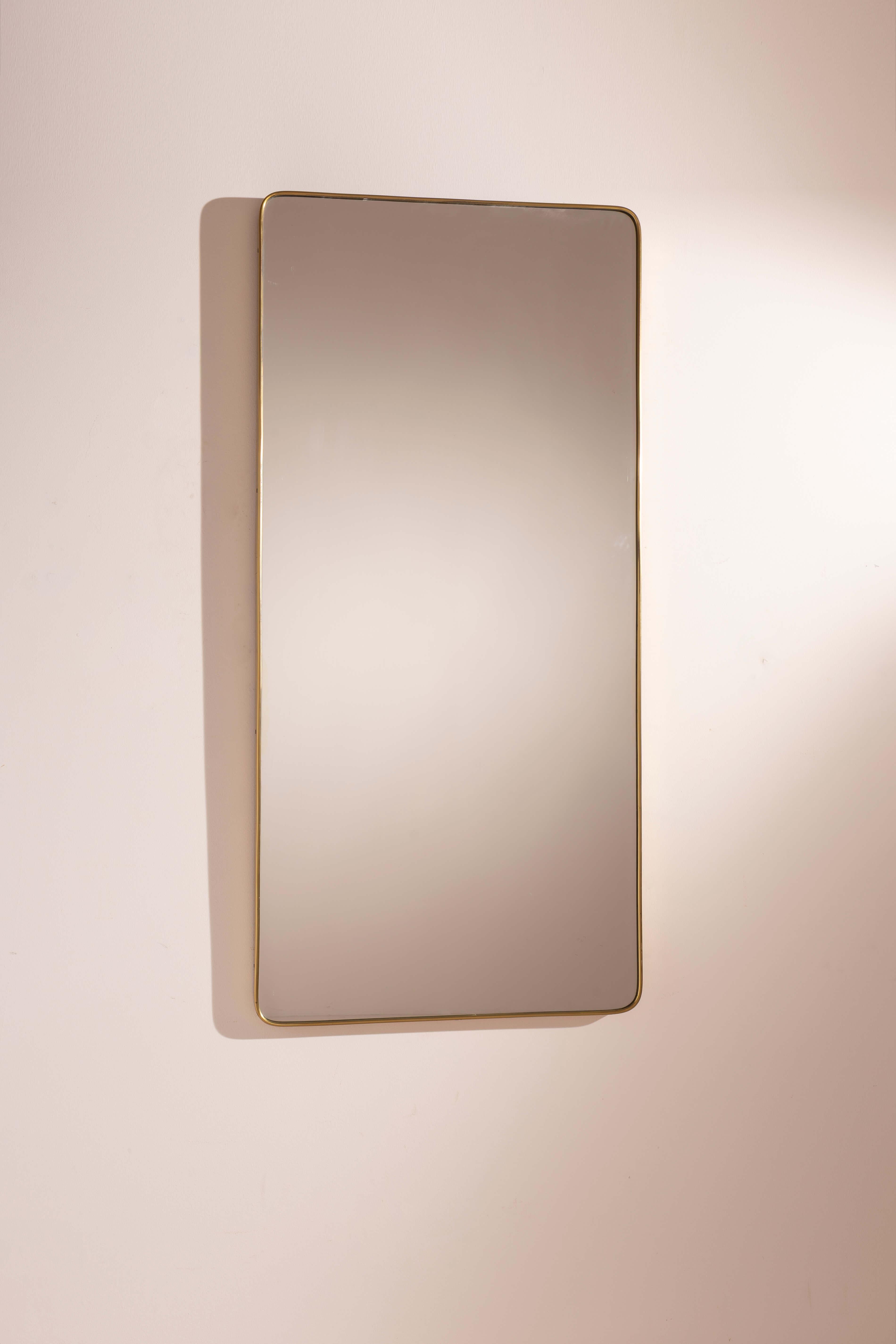 Miroir mural élégant et généreux, encadré de laiton, avec verre biseauté, de forme rectangulaire avec des coins arrondis, fabrication italienne, années 1950.

Ce grand miroir mural, avec sa forme gracieuse, est idéal pour mettre en valeur une