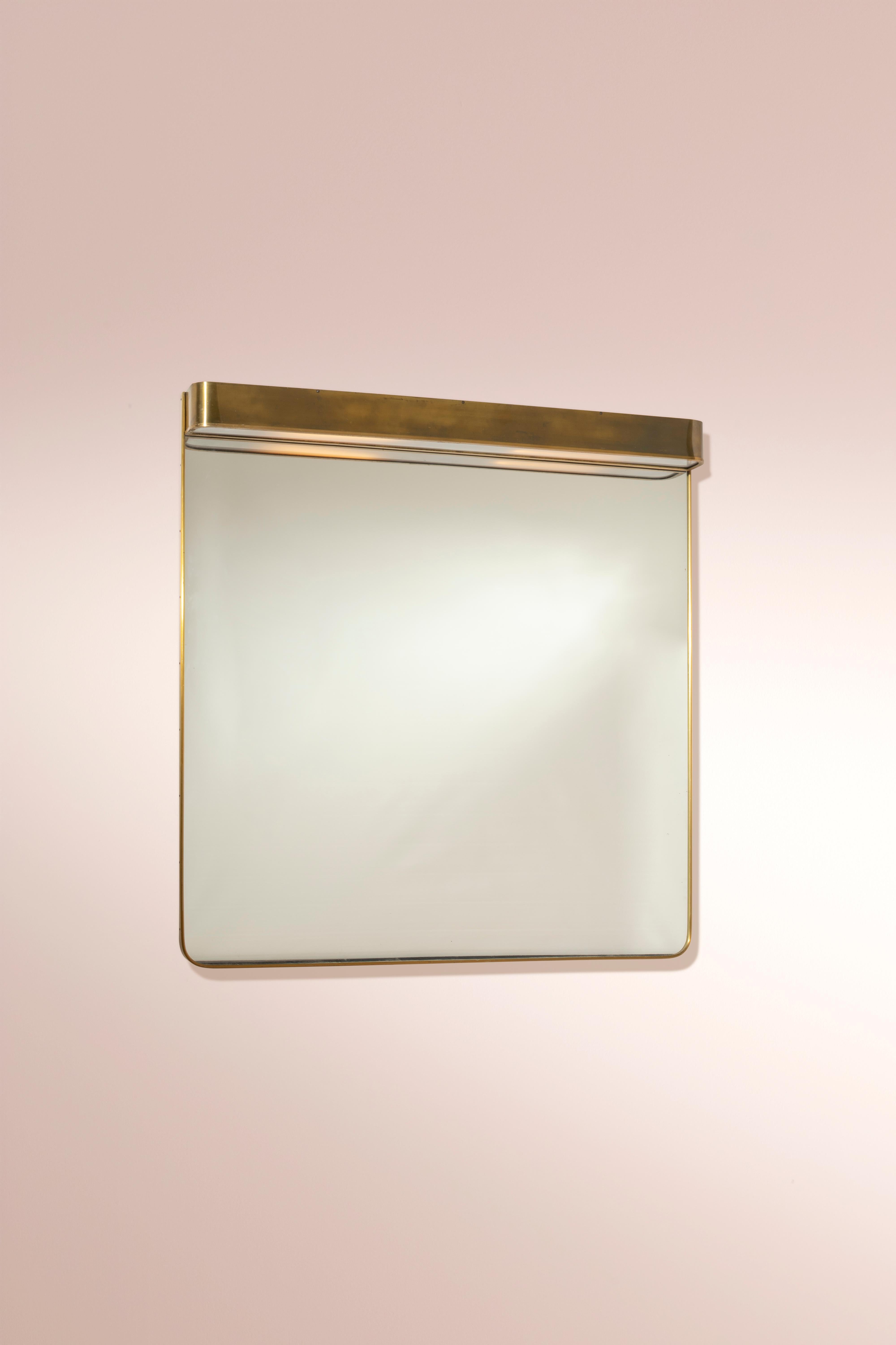 Large mirror with brass frame and integrated lamp, Italian manufacture, 1950s.

A mirror, when incorporated into interior design, always provides a reflection of light and color that adds depth and character to a space. This mirror, with its brass