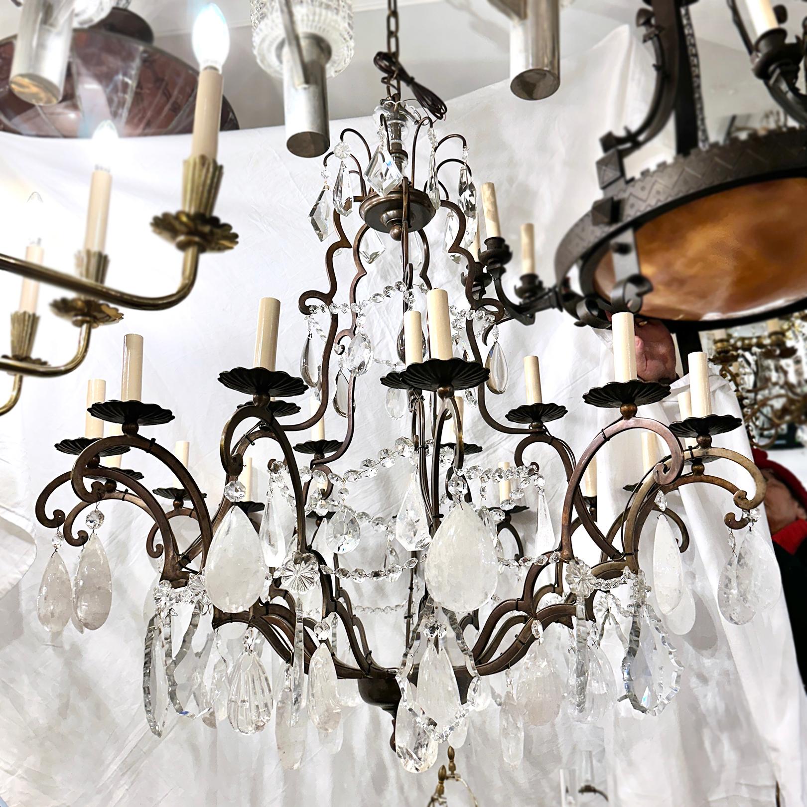 A circa 1950's French patinated bronze chandelier with 20 lights and with rock crystal pendants.

Measurements:
Minimum drop: 46