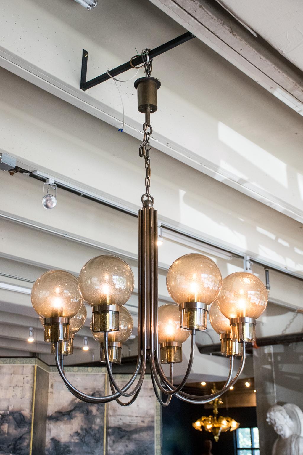 Heavy bronze chandelier with eight arched arms topped by hand blown smoked glass globes. Globes have subtle bubbles in the glass. Includes 8 LED bulbs. Heavy bronze canopy will cover US junction box. Wiring is new. Height reflects chandelier without