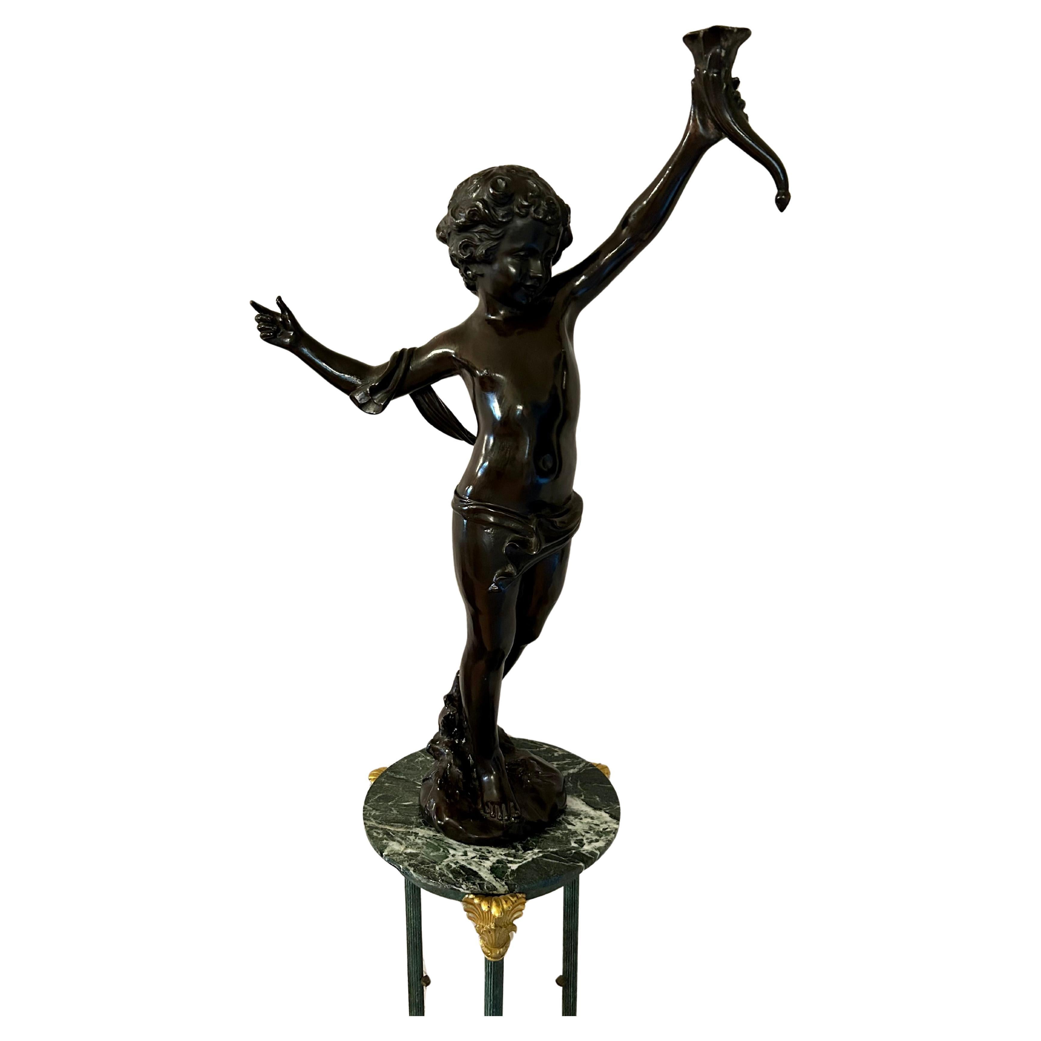 Una splendida scultura di un cherubino che regge una cornucopia, opera di August Moreau. Francese, inizio del XX secolo. Con un'altezza di 35 pollici, si tratta di un bronzo di grande spessore e in ottime condizioni. Il cherubino è in piedi con un