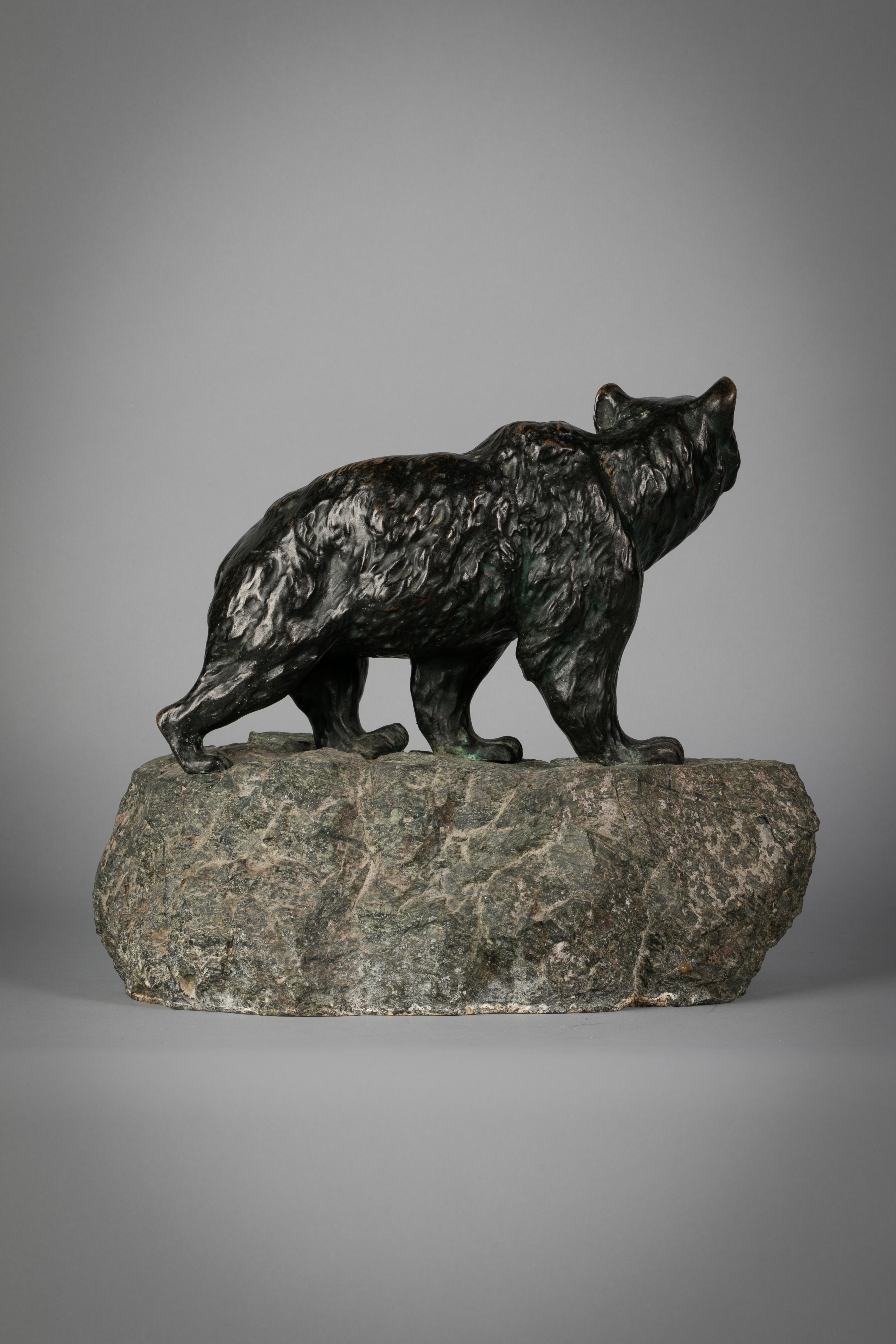 Large bronze figure of a striding bear, early 20th century on stone base.