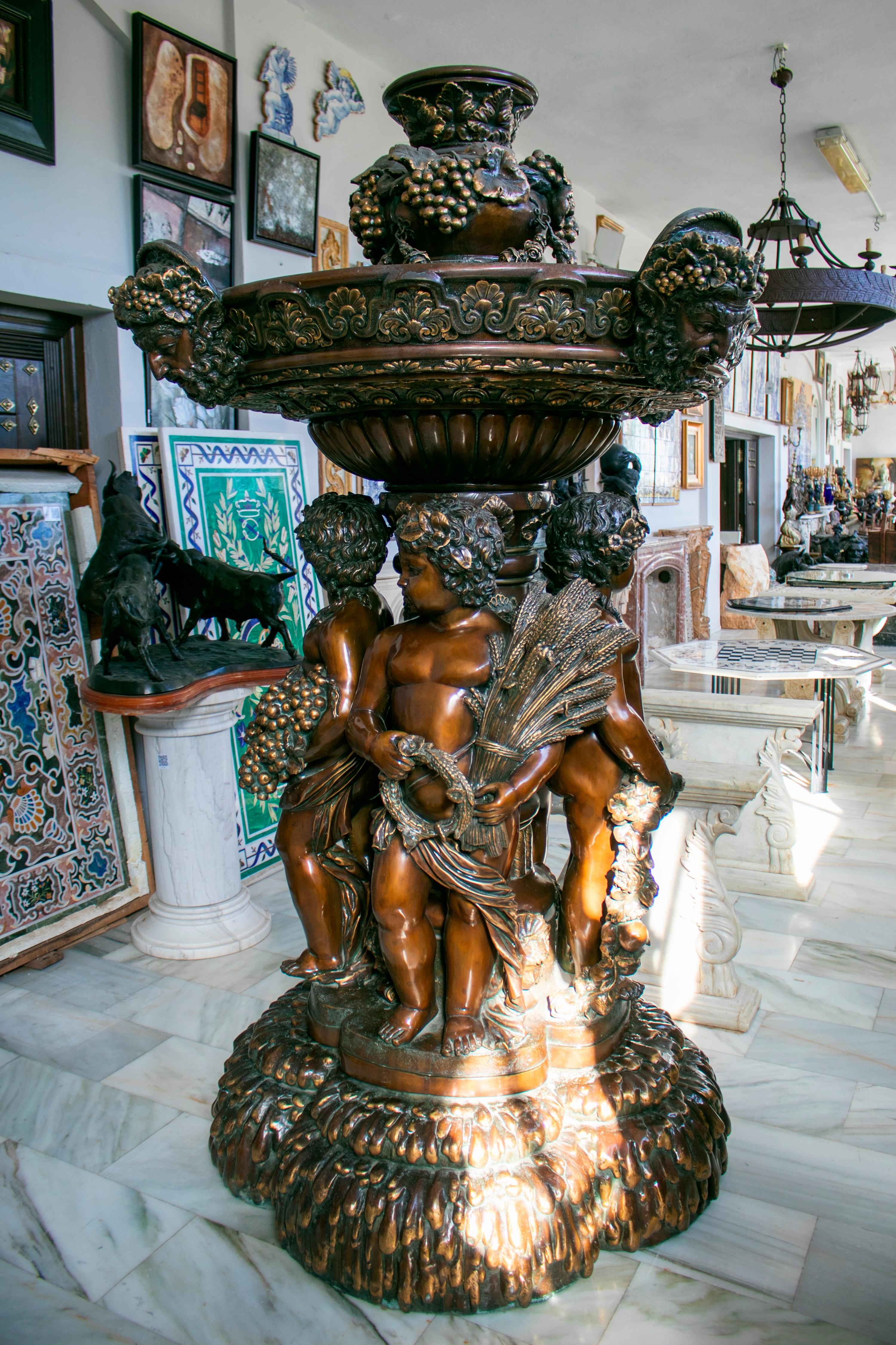 Large bronze four seasons cherub fountain with top tier and mascaron spouts. 

An exquisite polished patina make it ideal as an interior decoration piece and bronze is the highest quality when it comes to luxury in garden fountains and ornaments.