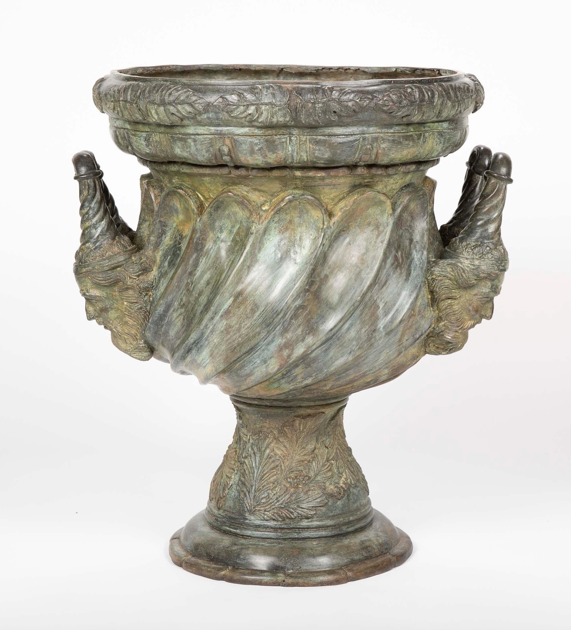 A substantial bronze garden urn with handles in the form of a bearded men having exceptional patination. After a model from the Palace of Versailles by Claude Ballin.

Copy of 1665 urn by Claude Ballin at Versailles. 