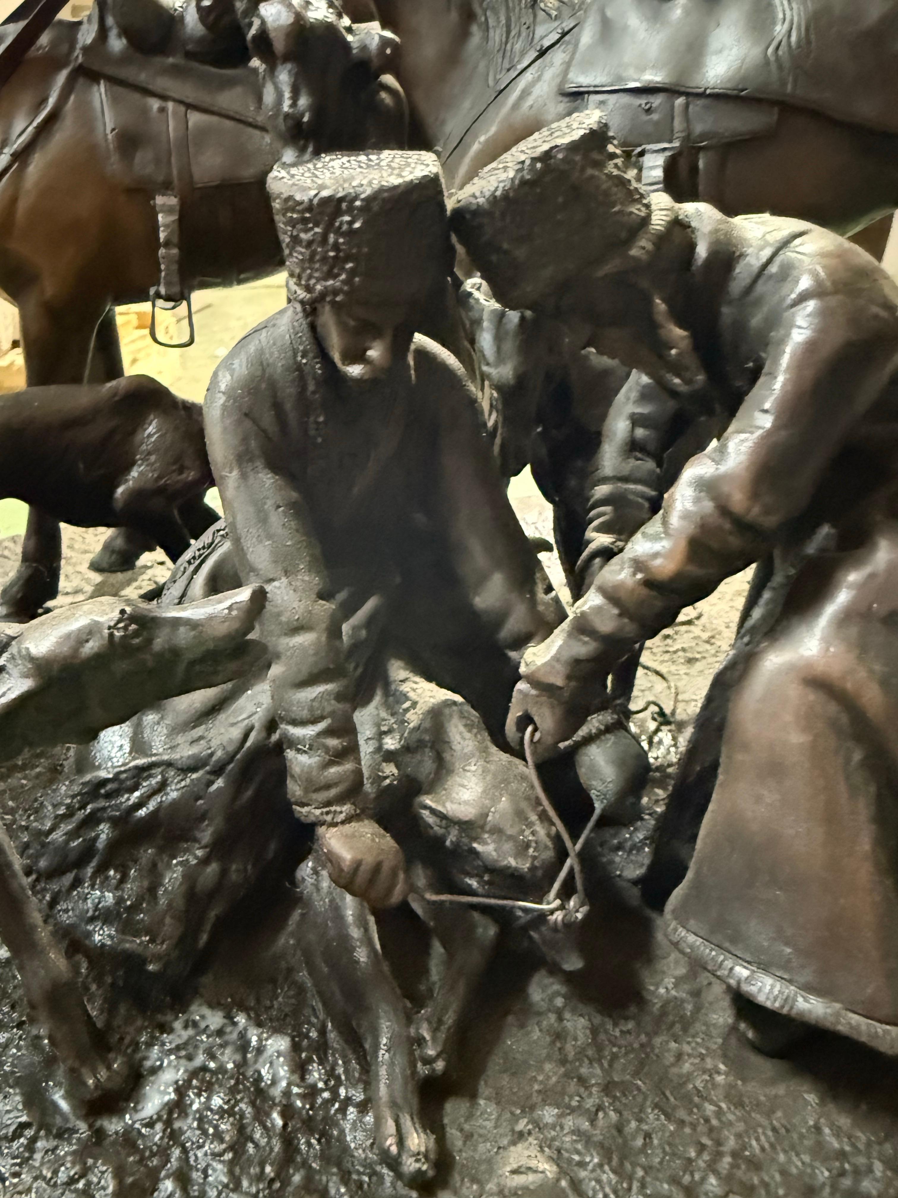 A dramatic and highly detailed bronze group sculpture depicting a moment of rest among cavalrymen, their horses, and hounds, signed Liebrecht. The composition captures a richly narrative scene: soldiers seated on the ground, gathered in discussion