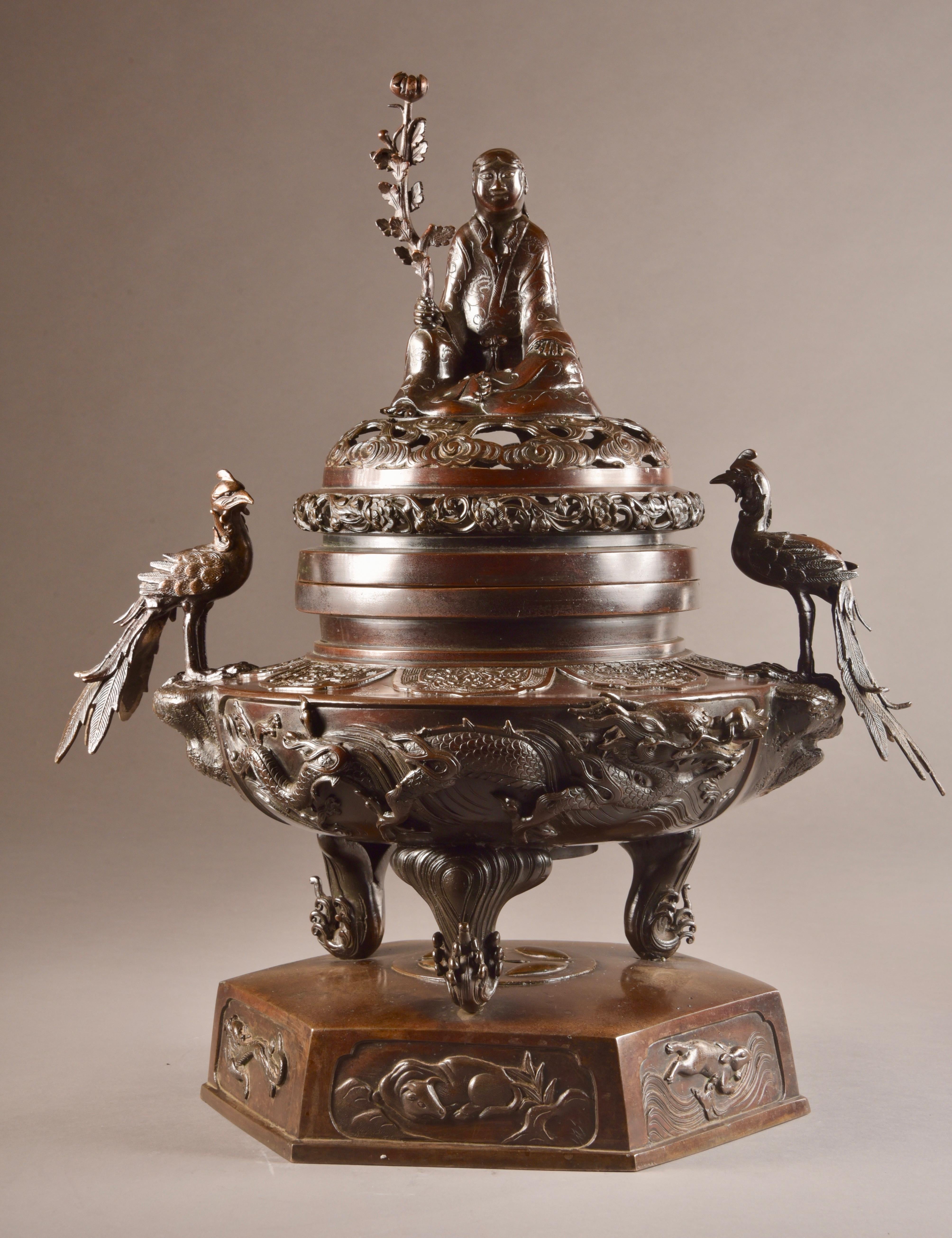 Very large and heavy two-piece incense burner with a finely finished large statue of Buddha with Lotus flower in his hand on the lid. Additionally, the incense burner is surrounded by various beautifully finished dragons. The hexagonal base is